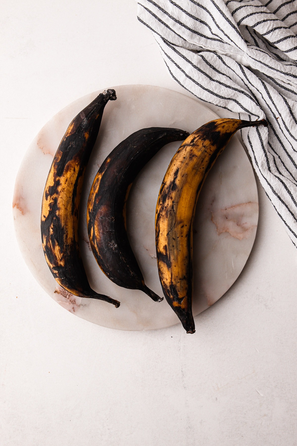 Plantains that are black with spots of yellow.