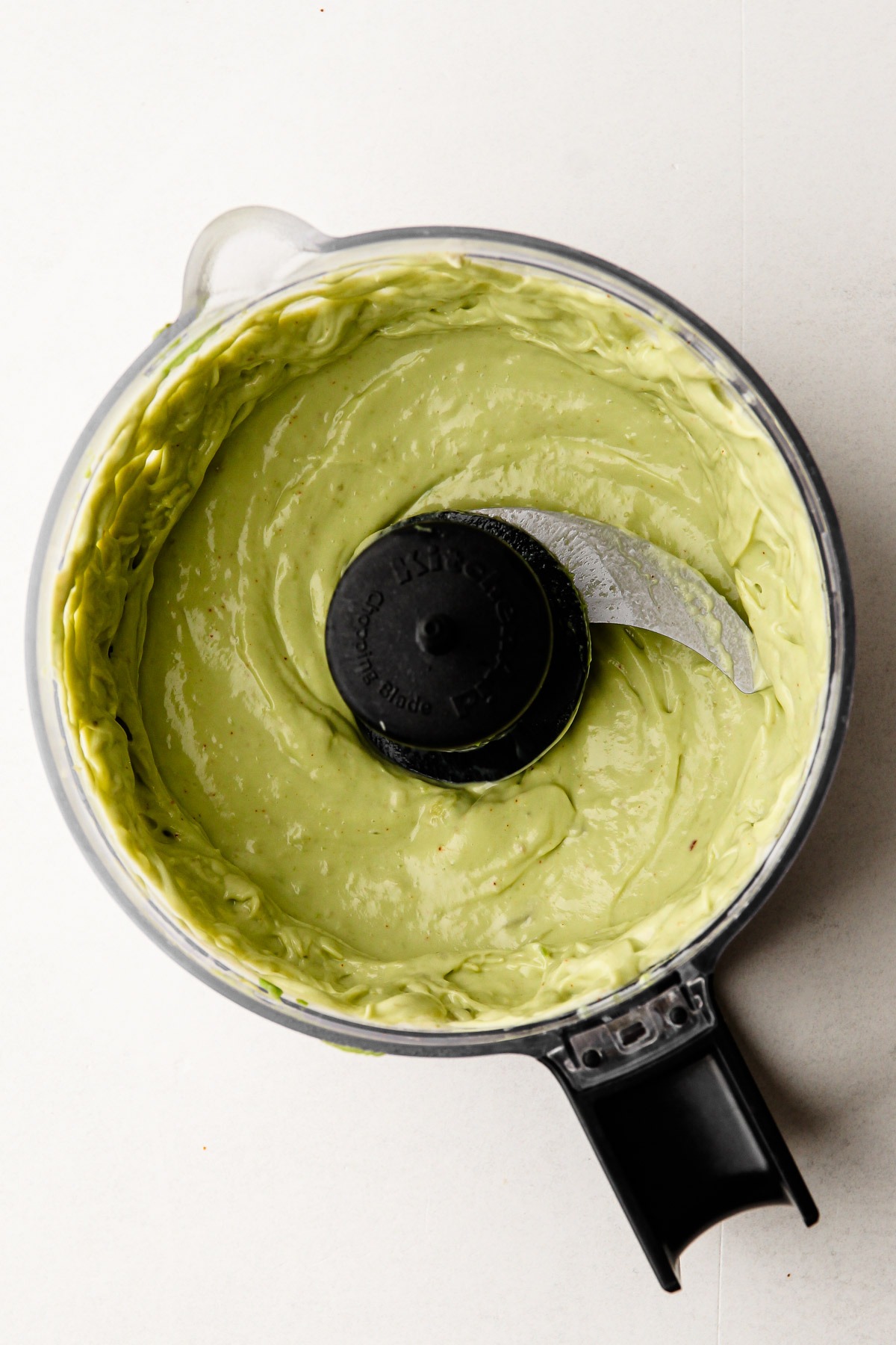 An avocado dip in a food processor that will be served with the air fried sweet potato wedges.