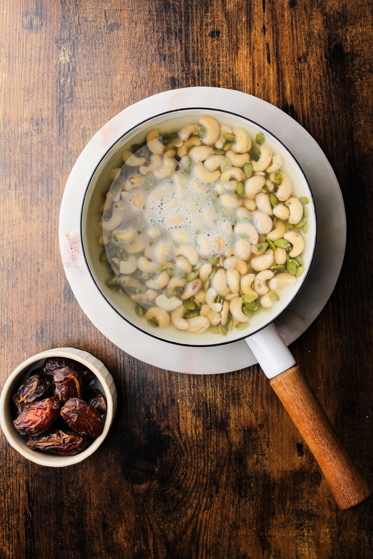 Soaking pumpkin seeds and cashews in a pot.