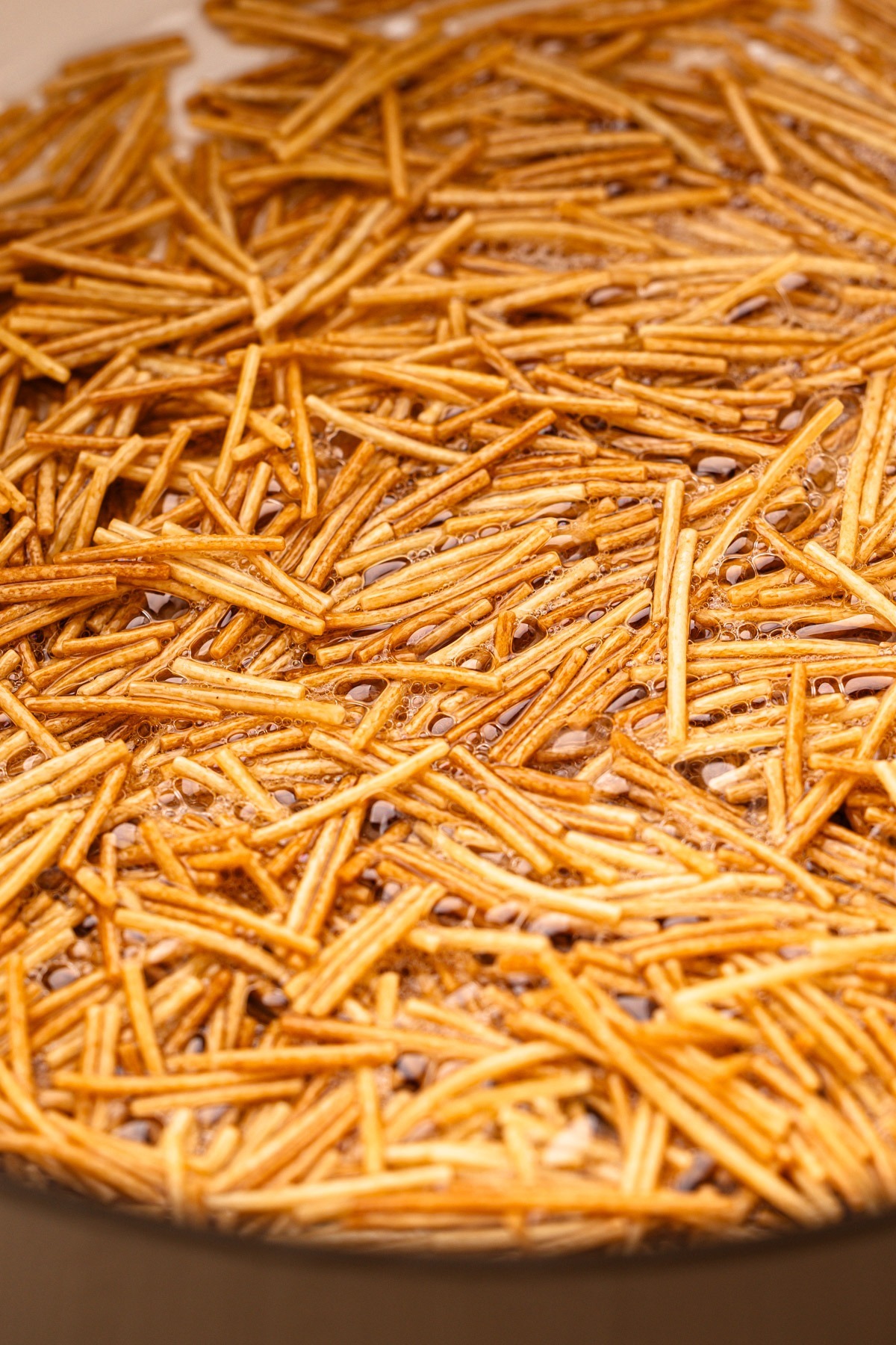 Frying pieces of little spaghetti called fideos.