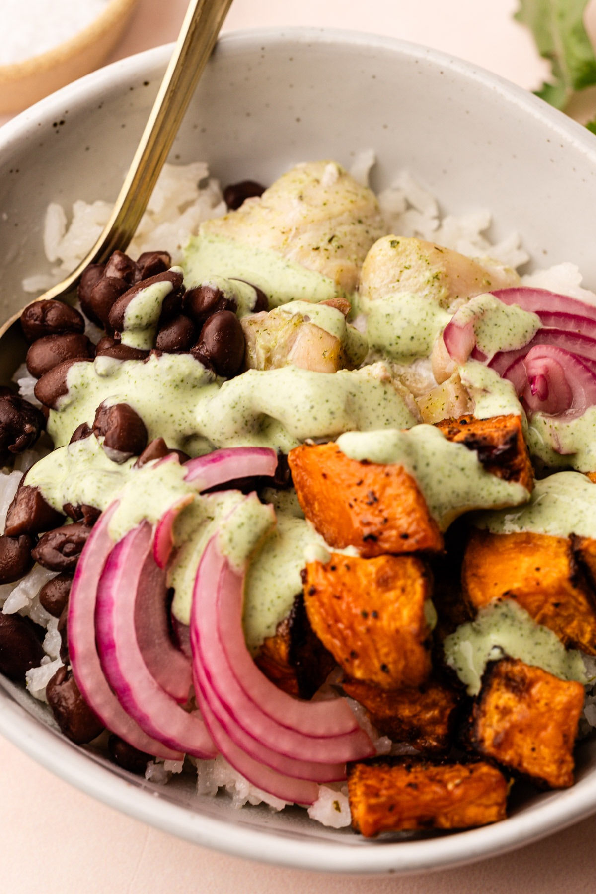 Cilantro sauce served over a chicken and bean bowl.