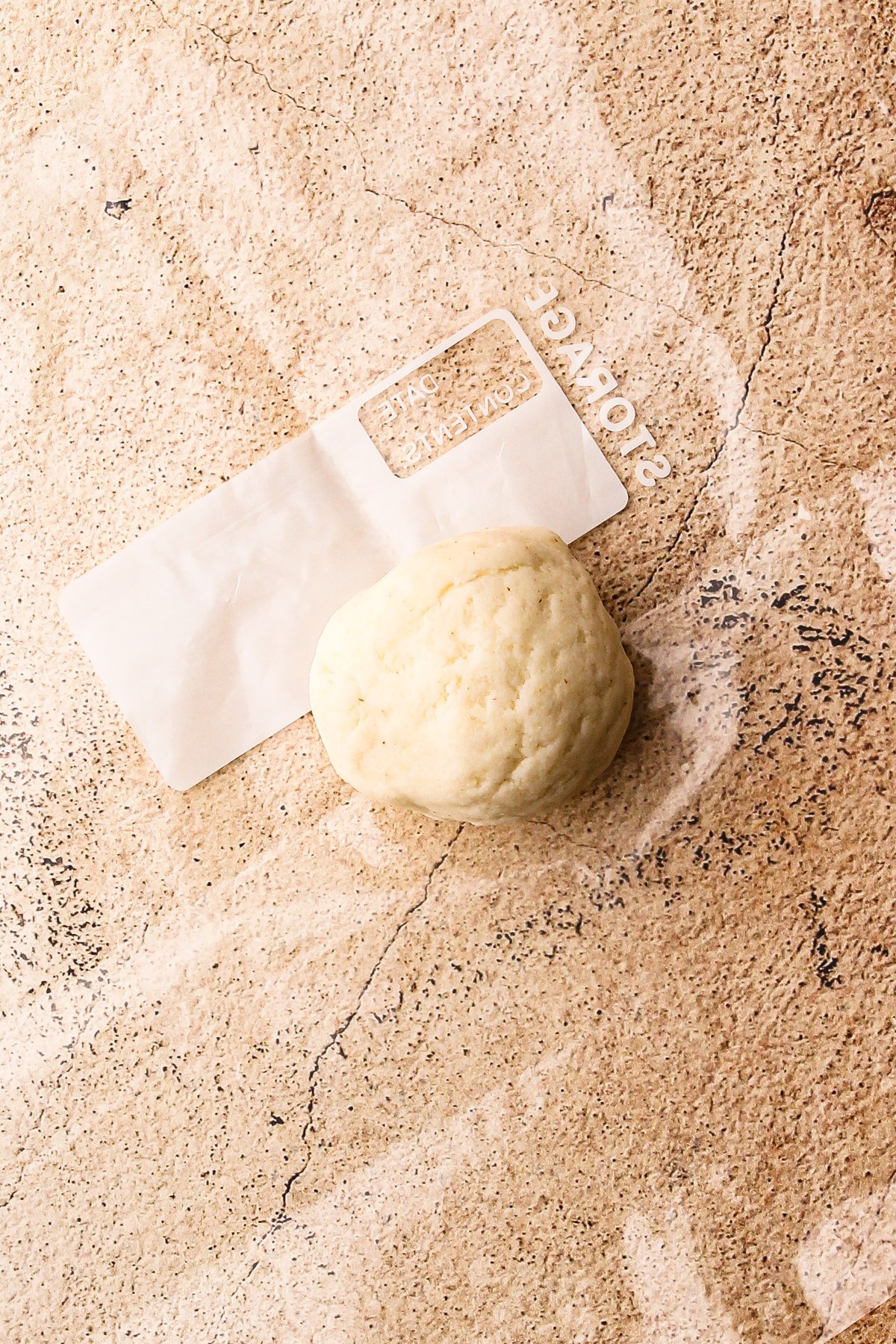 A ball of arepa dough on a sheet of plastic.