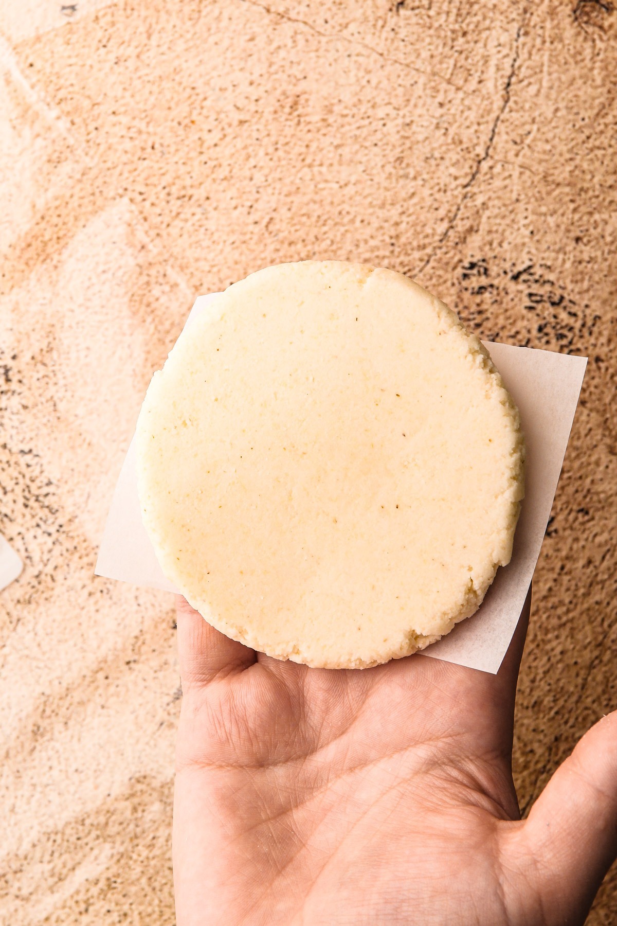 A formed arepa on a piece of parchment.