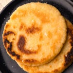 A plate of two cooked arepas.