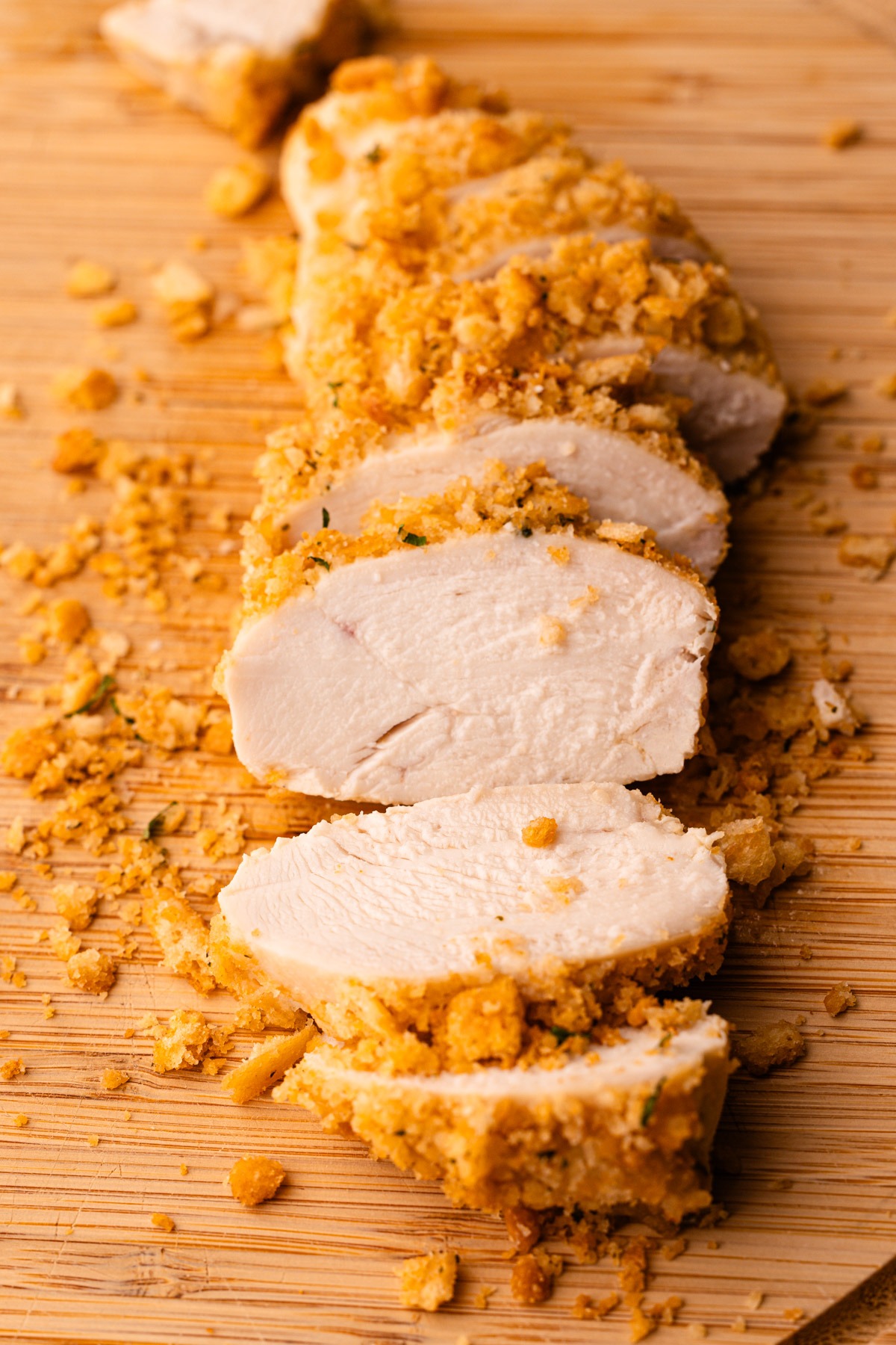 Sliced ritz cracker chicken on a cutting board.