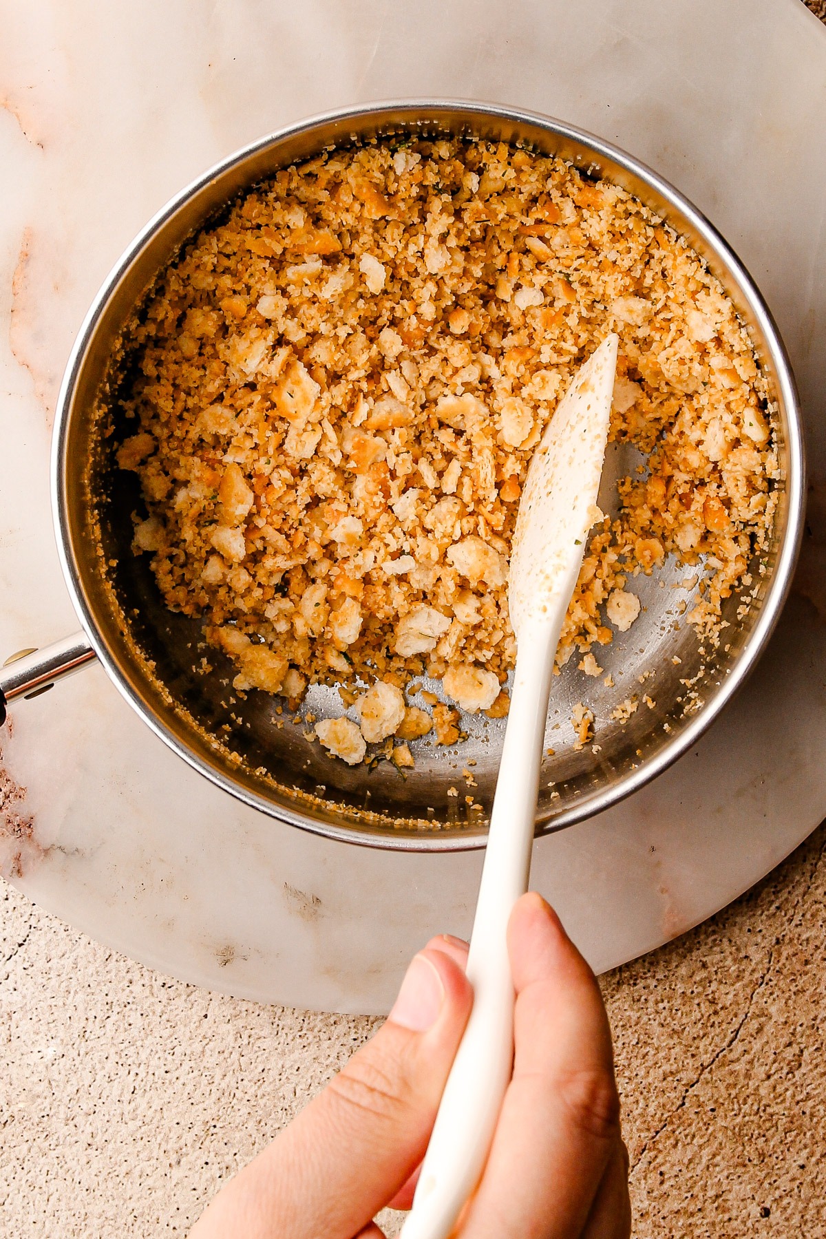 Toasting ritz crackers with butter in a small pot.