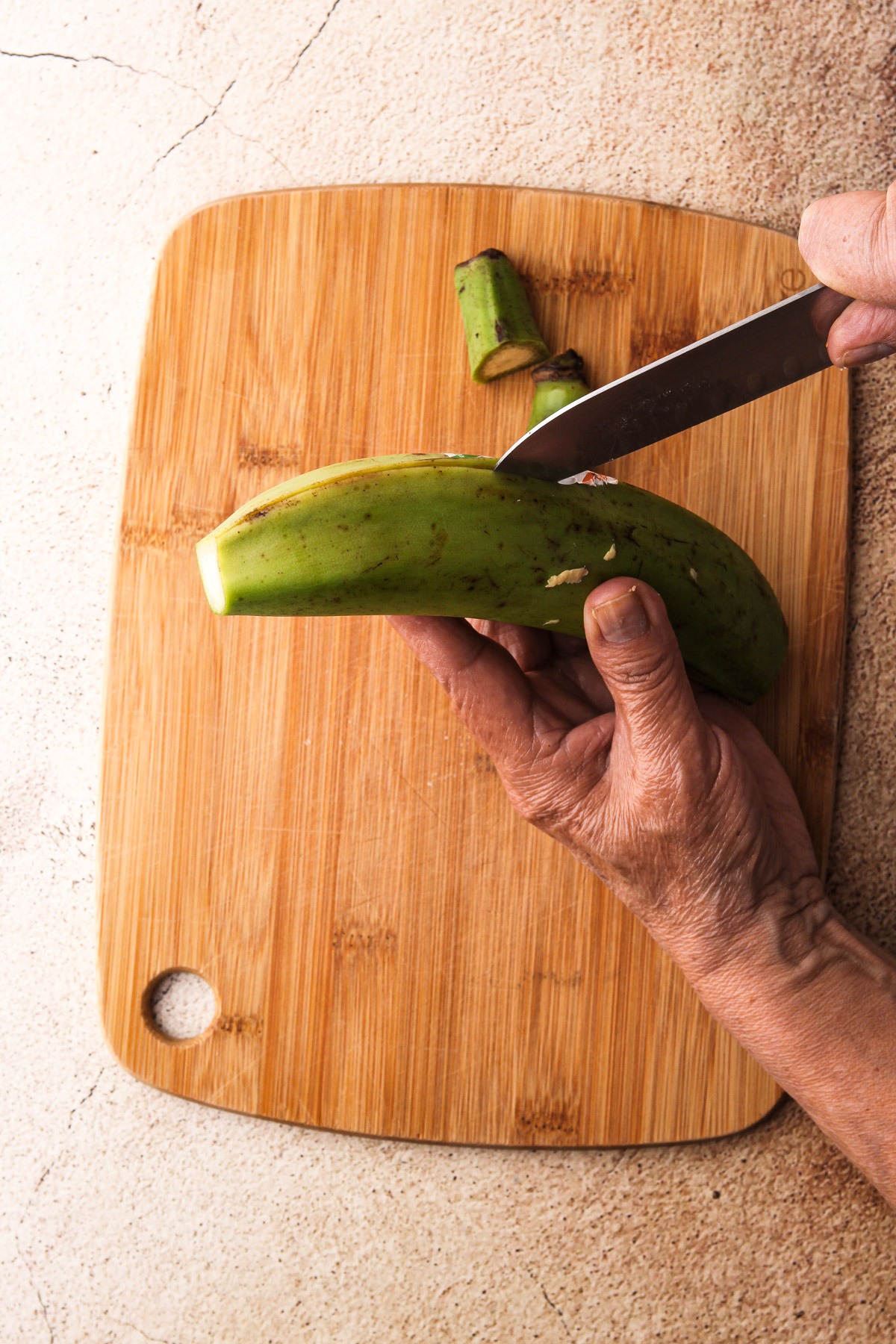 Cutting open a green plantain/