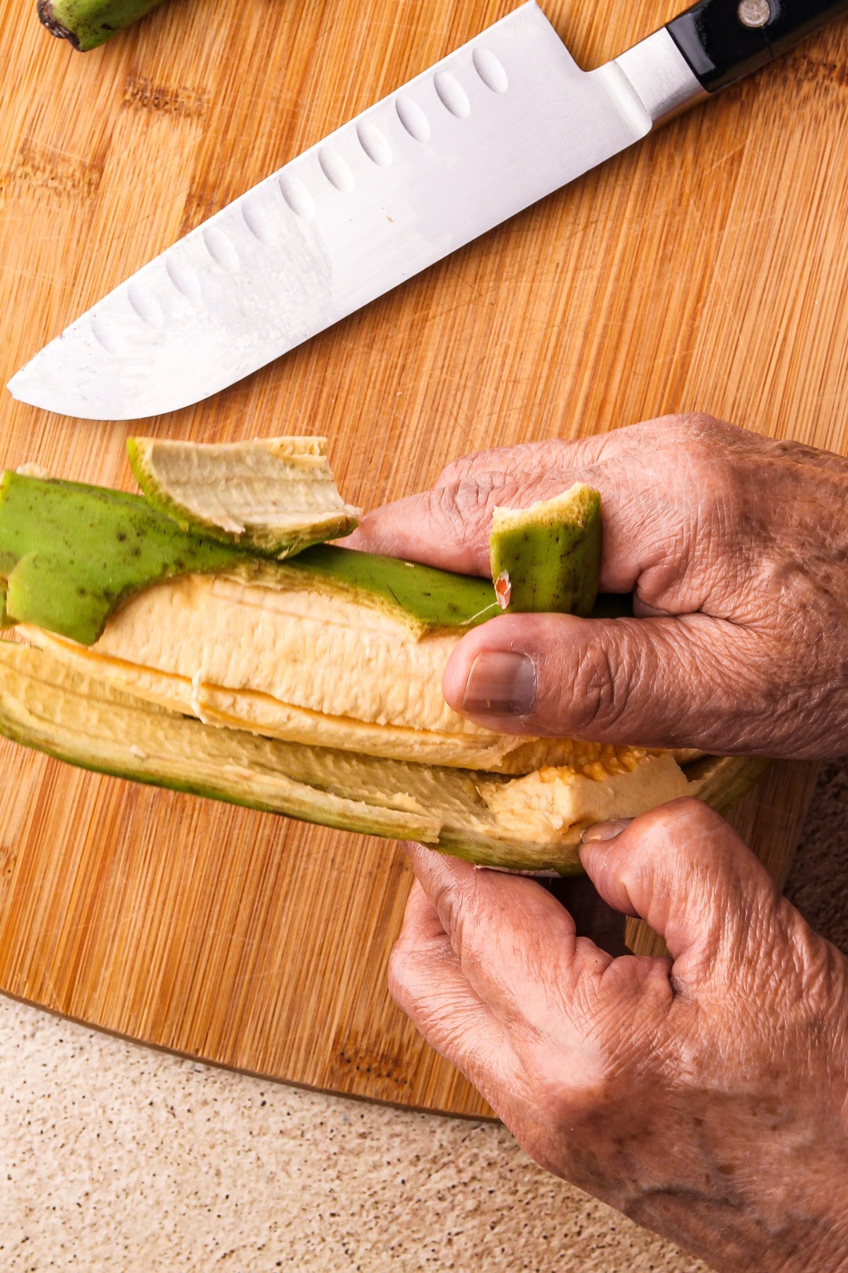 Taking the green skin off a plantain.