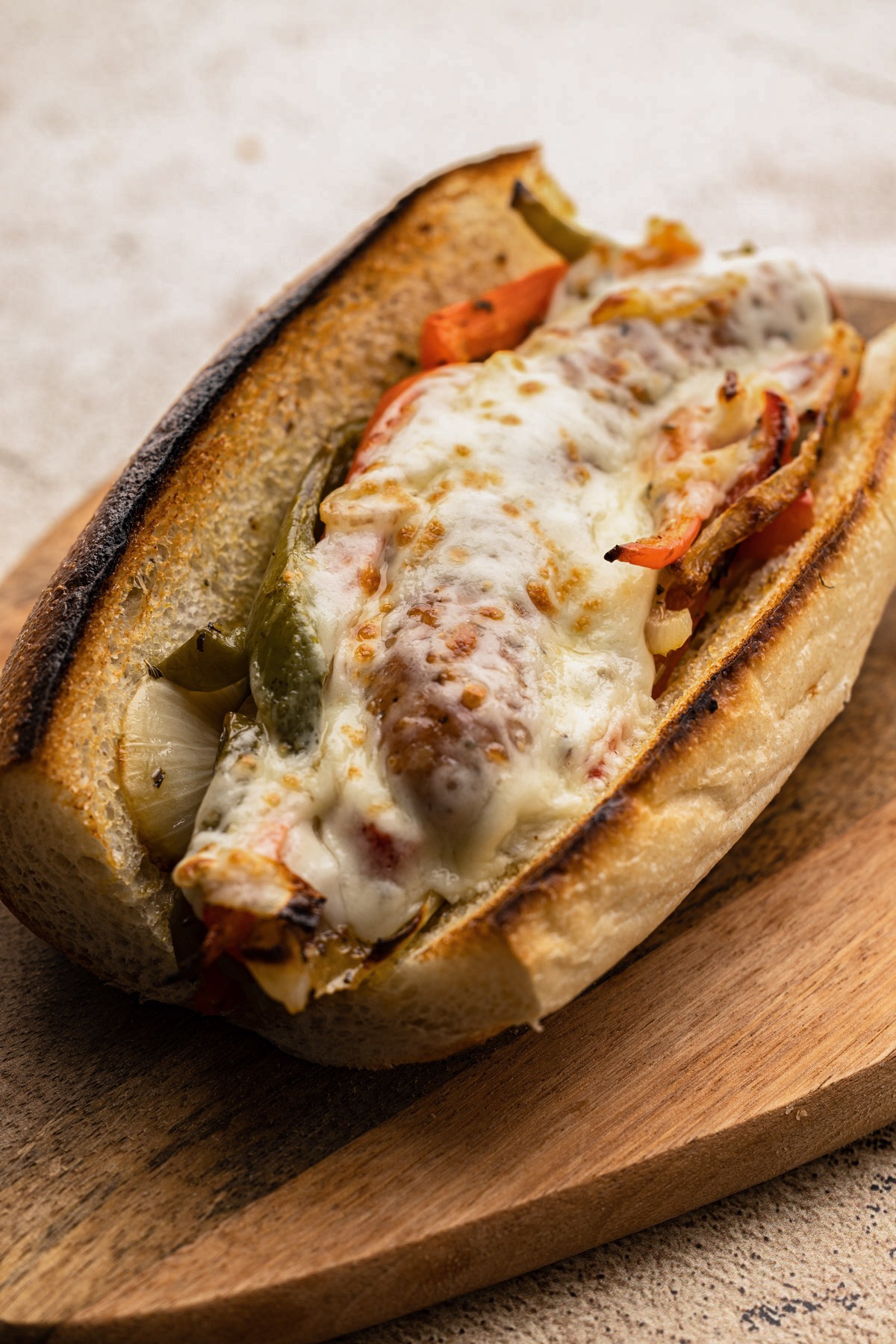 A sausage pepper and onion sandwich baked in the oven.