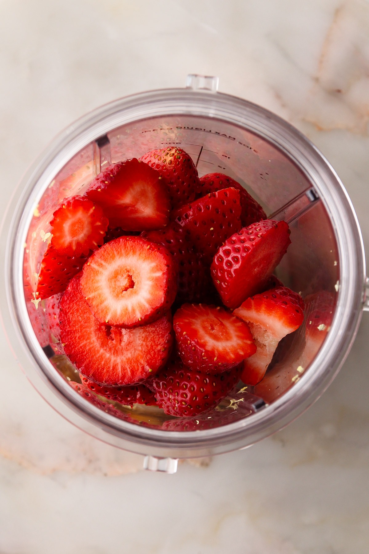 A blender with ingredients for strawberry milk.