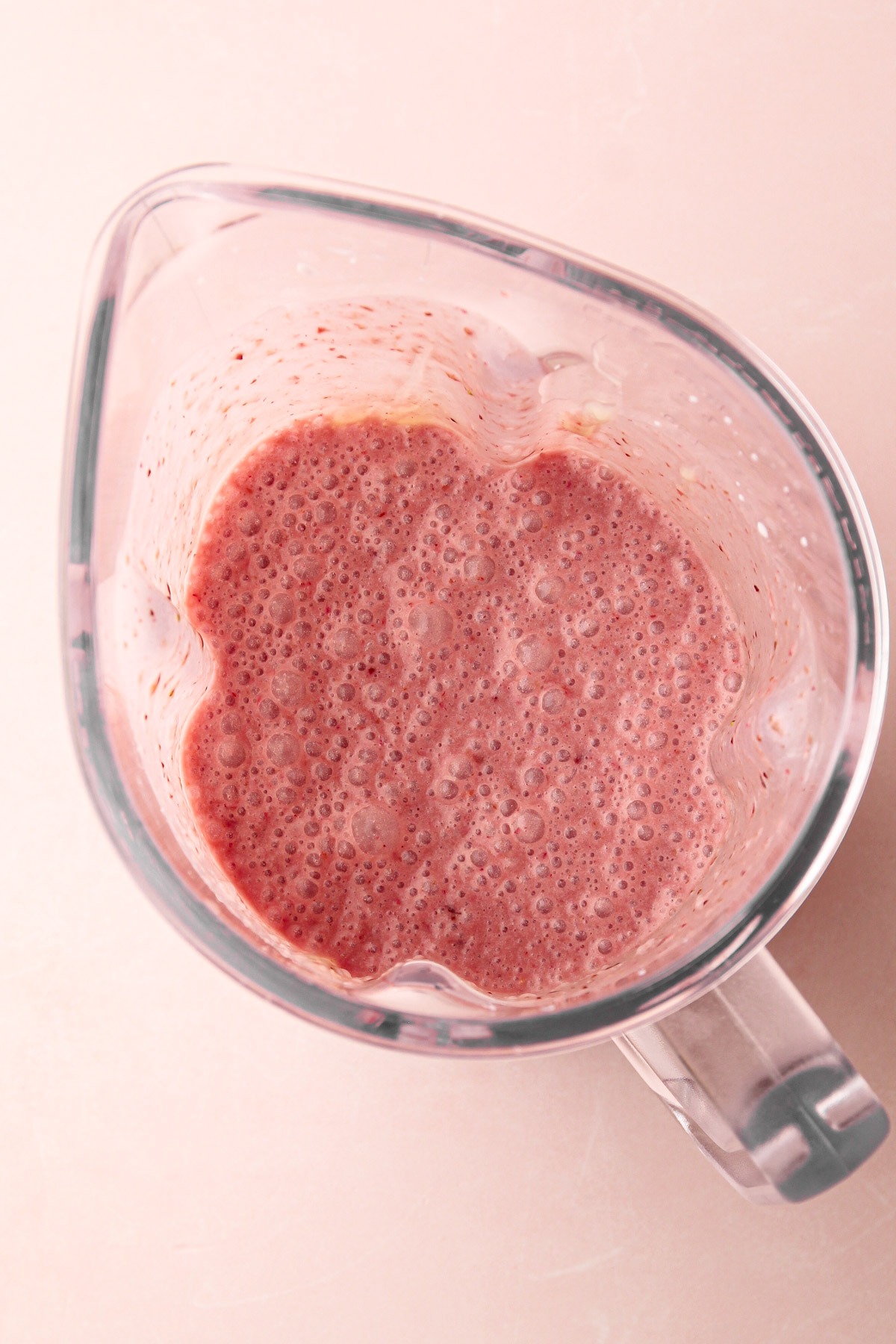 Blender with mixed strawberry and cream mixture for strawberry shortcake popsicles.