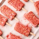 Tray of strawberry shortcake popsicles with crumbly coating, ready to be served.