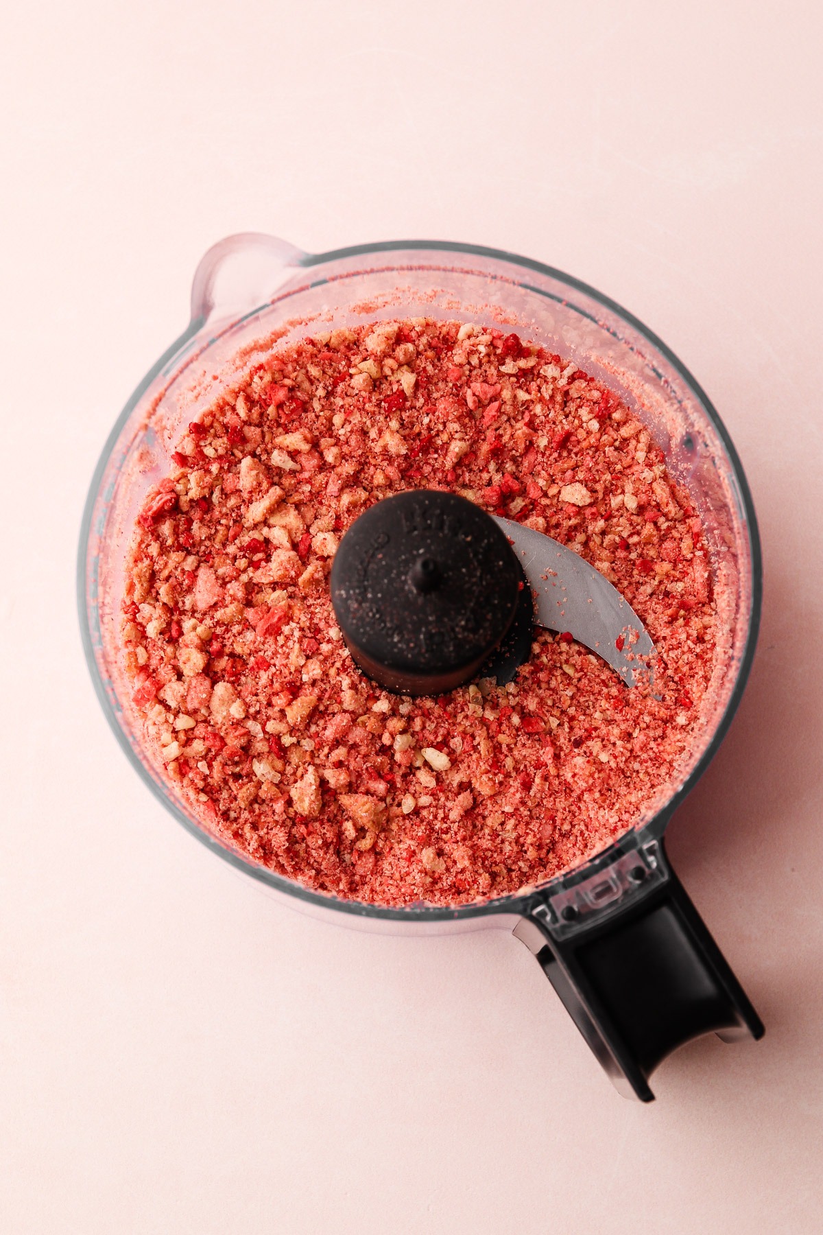 Food processor with finely ground crumb mixture for strawberry shortcake popsicles.