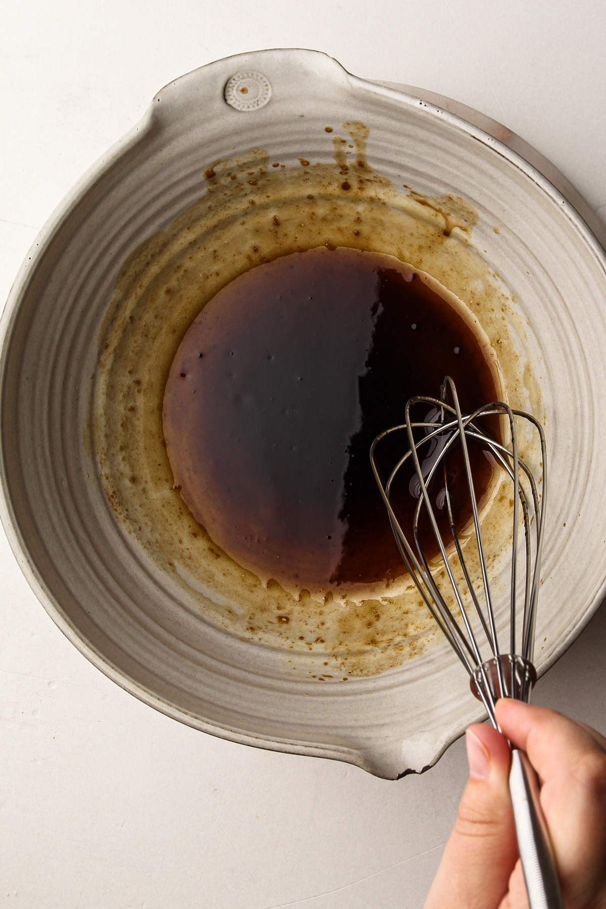 Whisking balsamic vinaigrette in a bowl for a caprese panzanella.