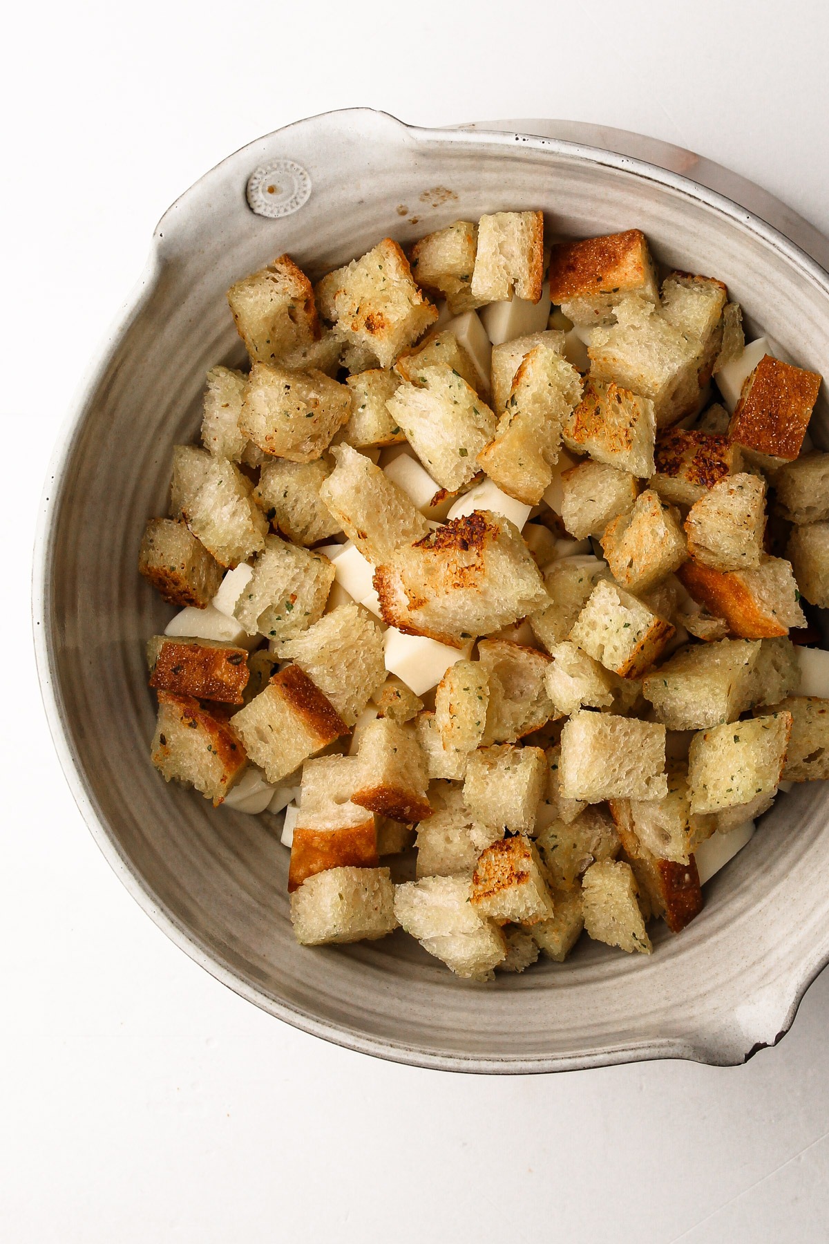 Fresh garlic butter bread added on top of cheese and tomatoes for a caprese panzanella salad.