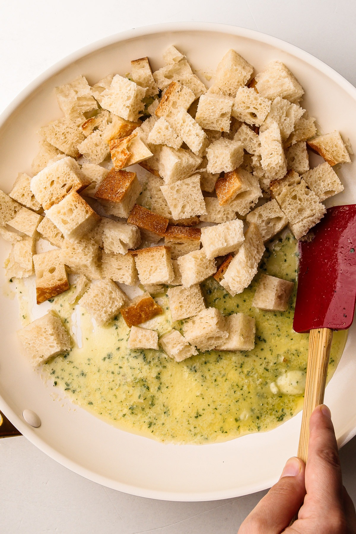 Bread cubes soaking in garlic butter, getting ready for a caprese panzanella salad.