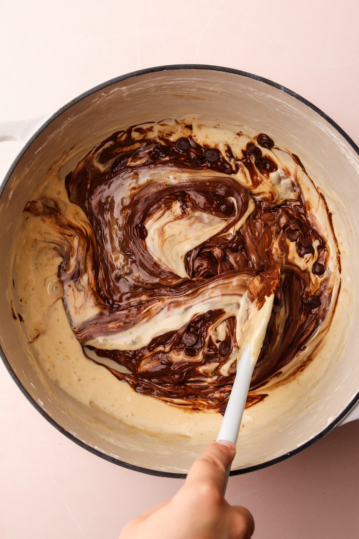 Stirring the melted chocolate mixture into the malted melted marshmallows.