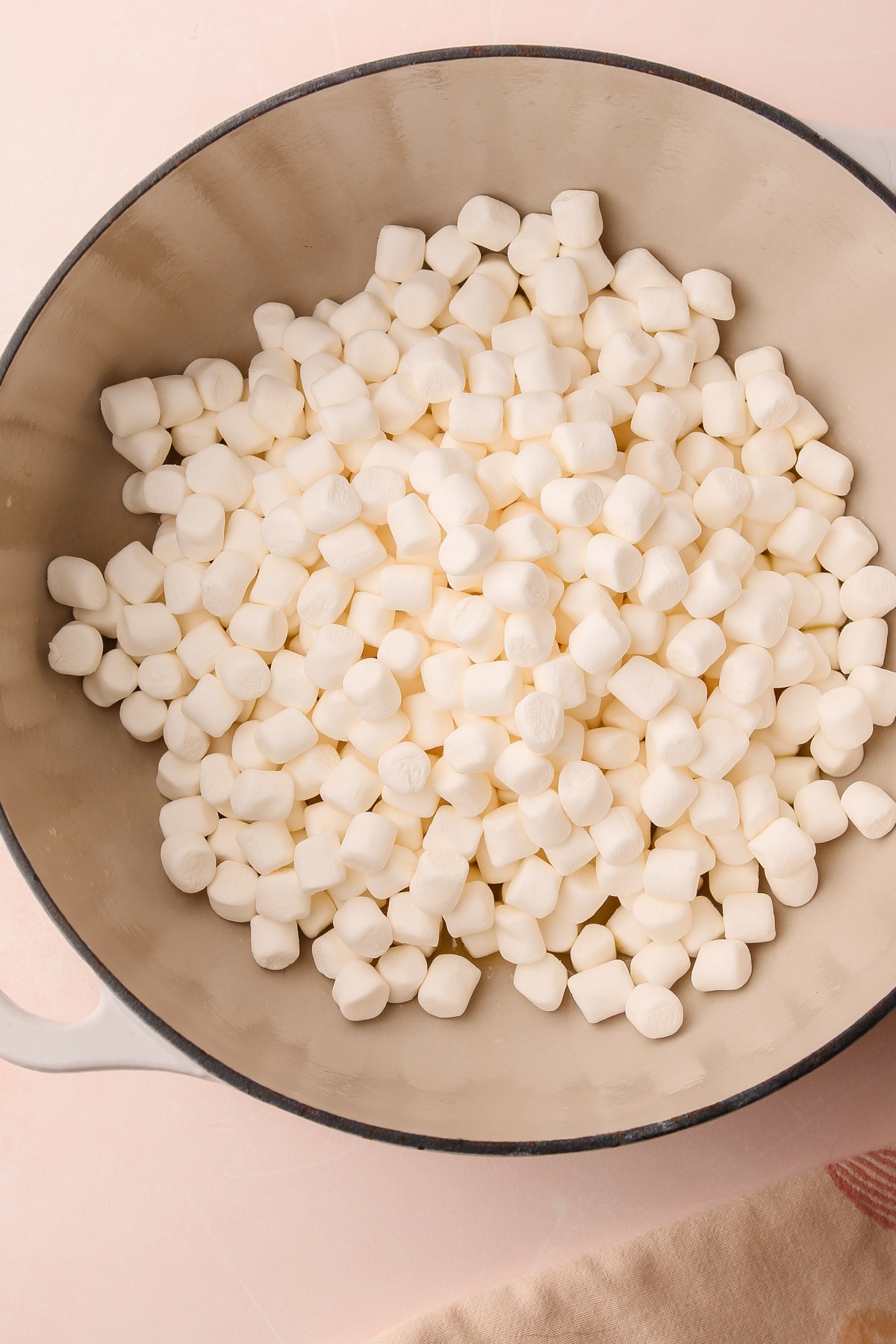 Marshmallows in a pot with melted butter for chocolate rice crispy treats.