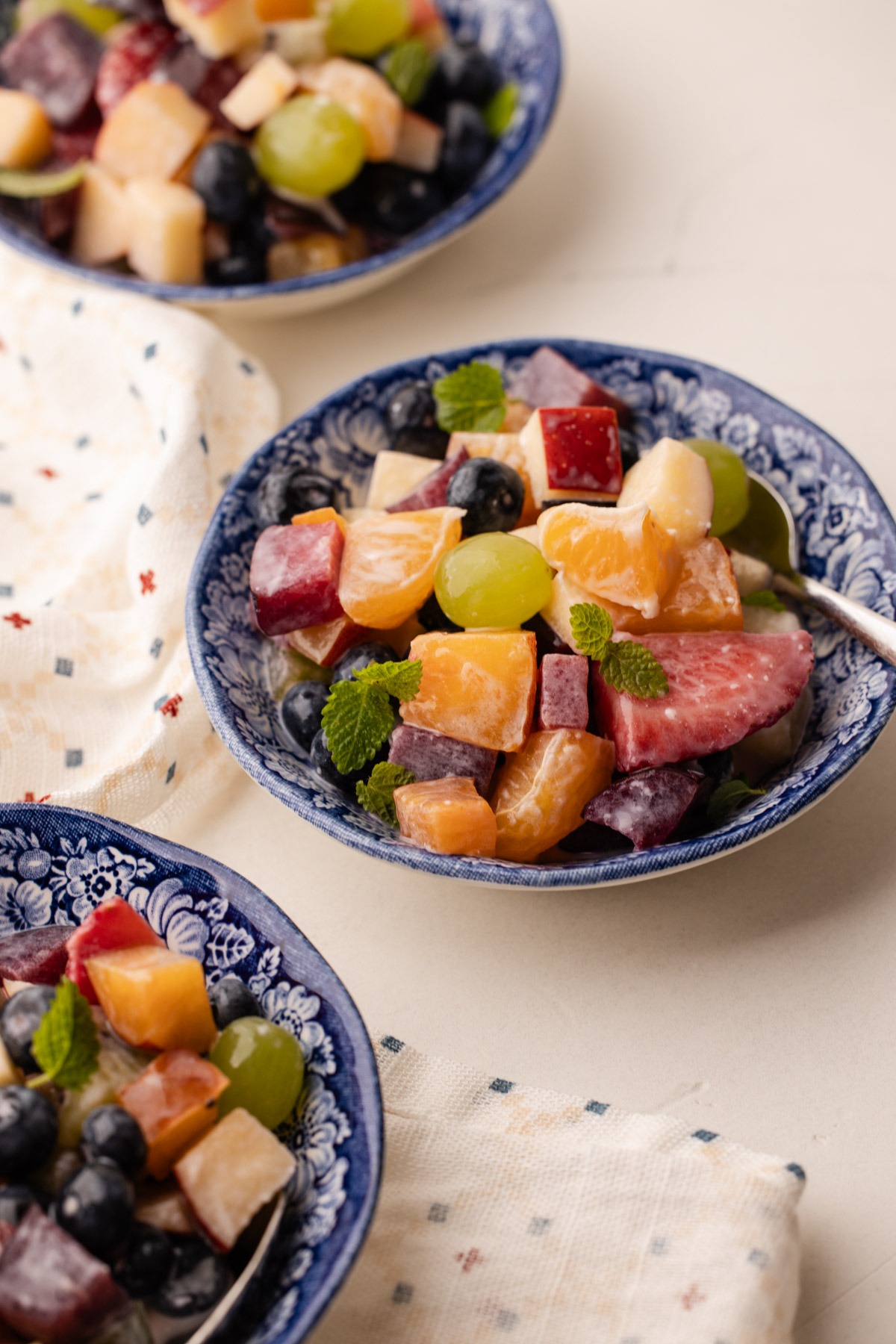 A serving of condensed milk fruit salad in a blue and white bowl.