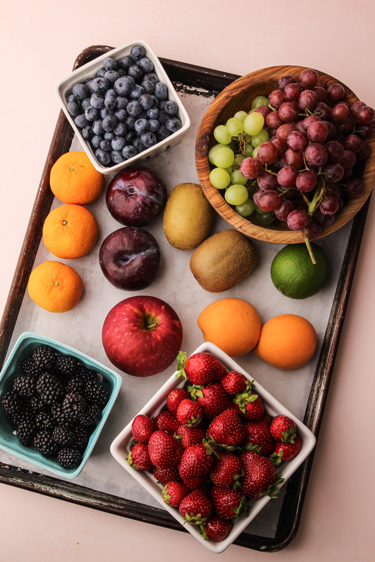 Ingredients for a fruit salad with condensed milk on a sheet tray.