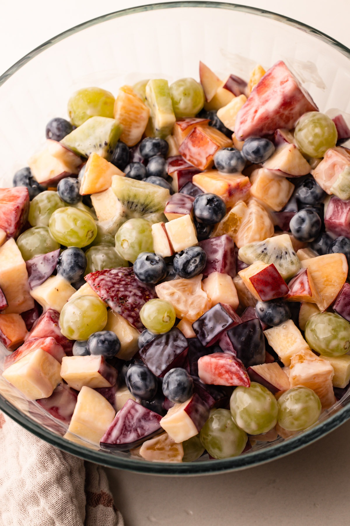 A bowl of fruit salad with condensed milk.