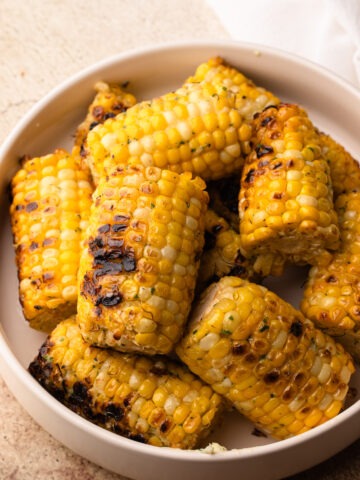 Grilled corn with a golden, charred exterior, seasoned with parmesan garlic butter.