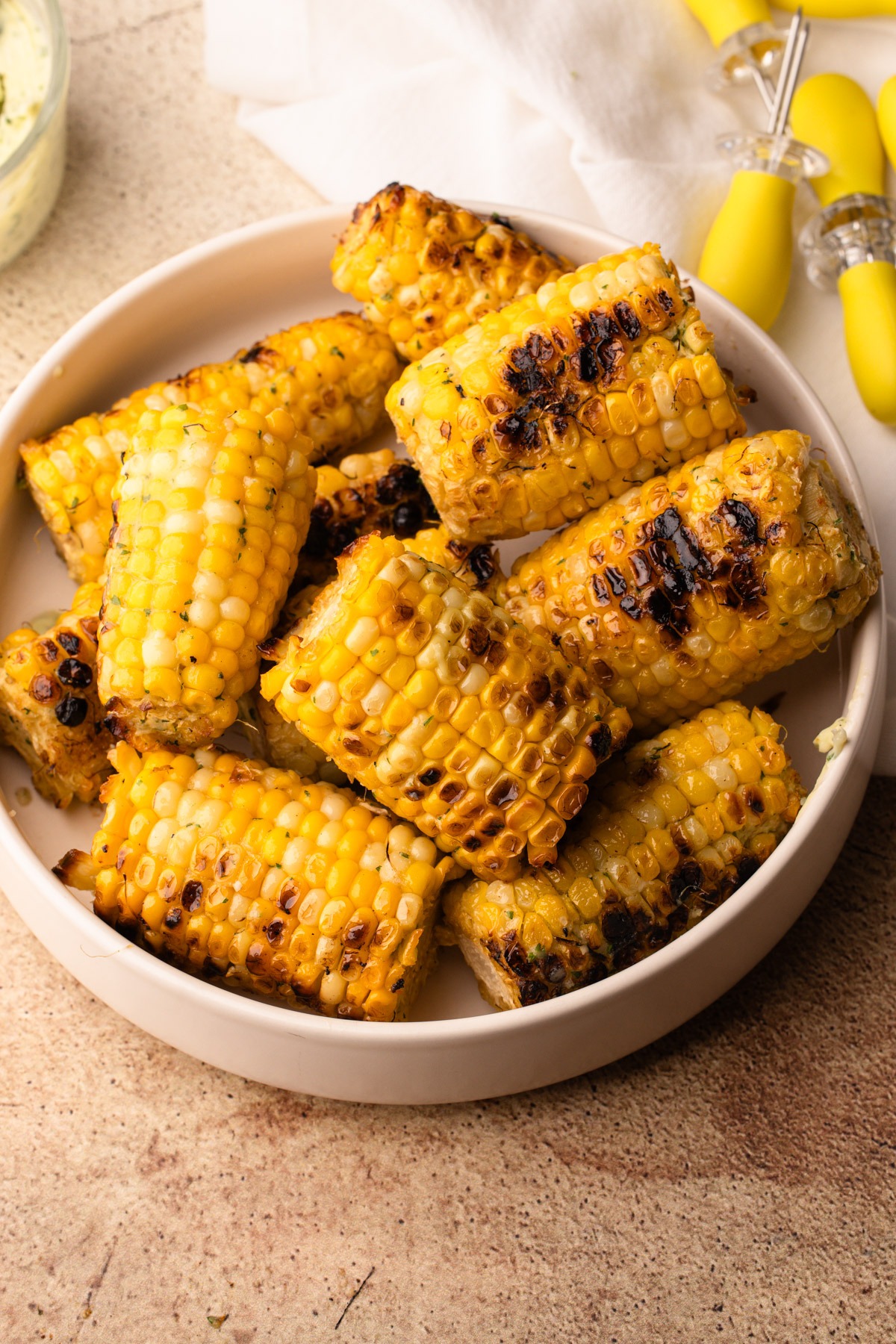 Grilled corn with a golden, charred exterior, seasoned with parmesan garlic butter.