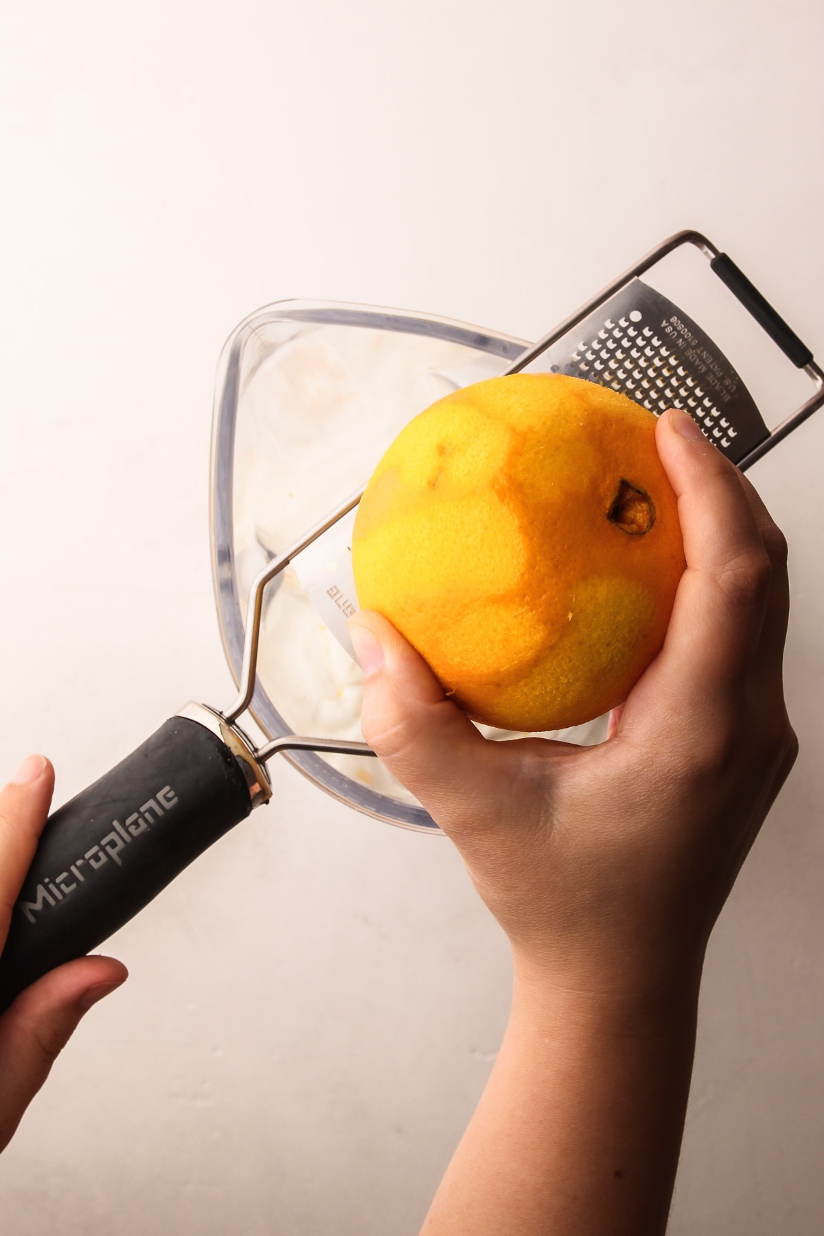 Grating orange zest for homemade orange creamsicles.