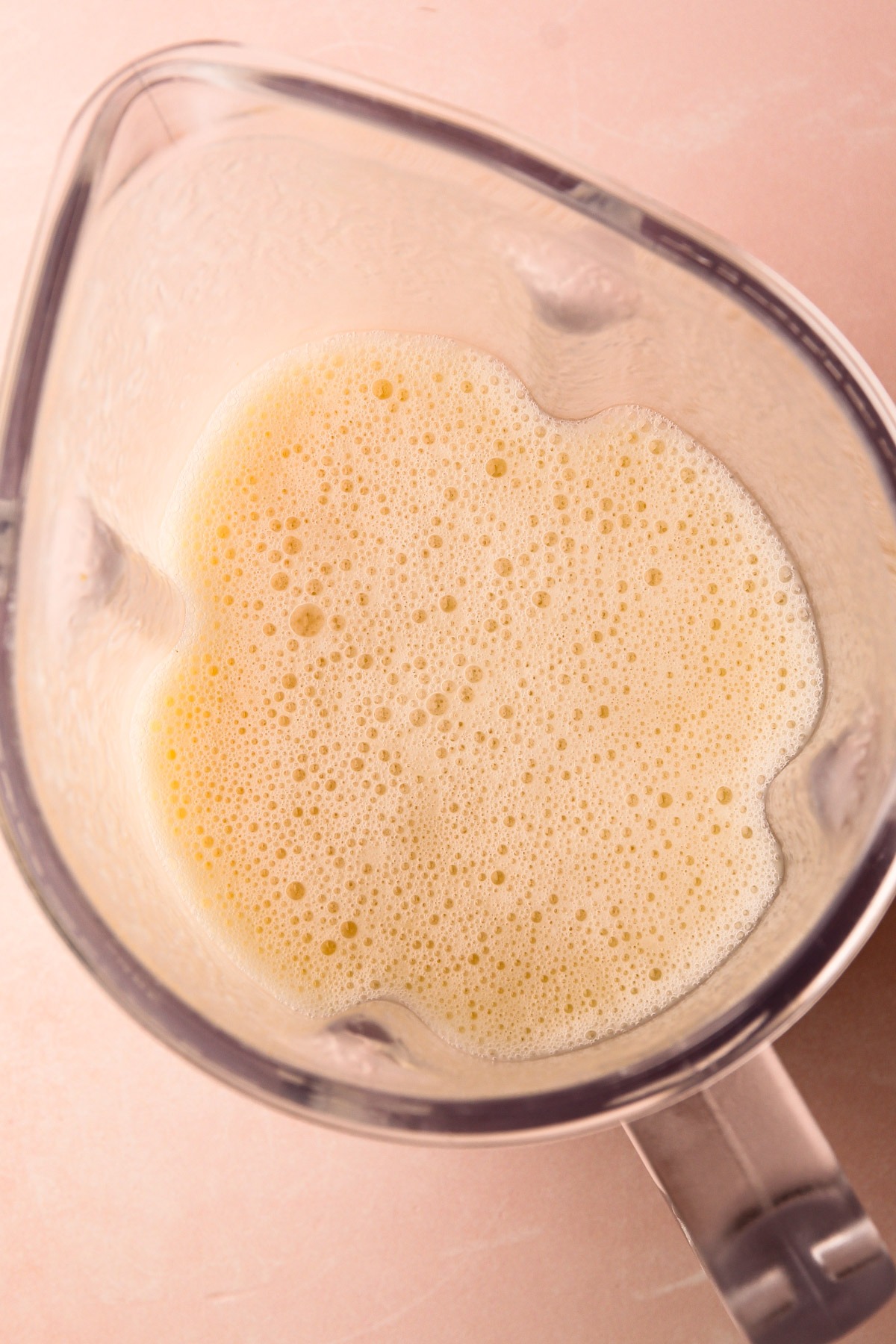 Frothy pineapple coconut mixture in a blender.