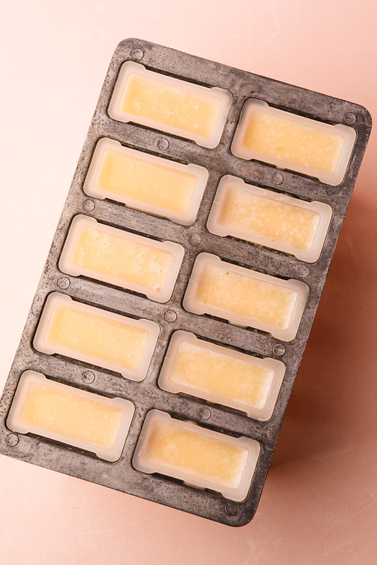 Popsicle mold filled with pineapple coconut mixture.