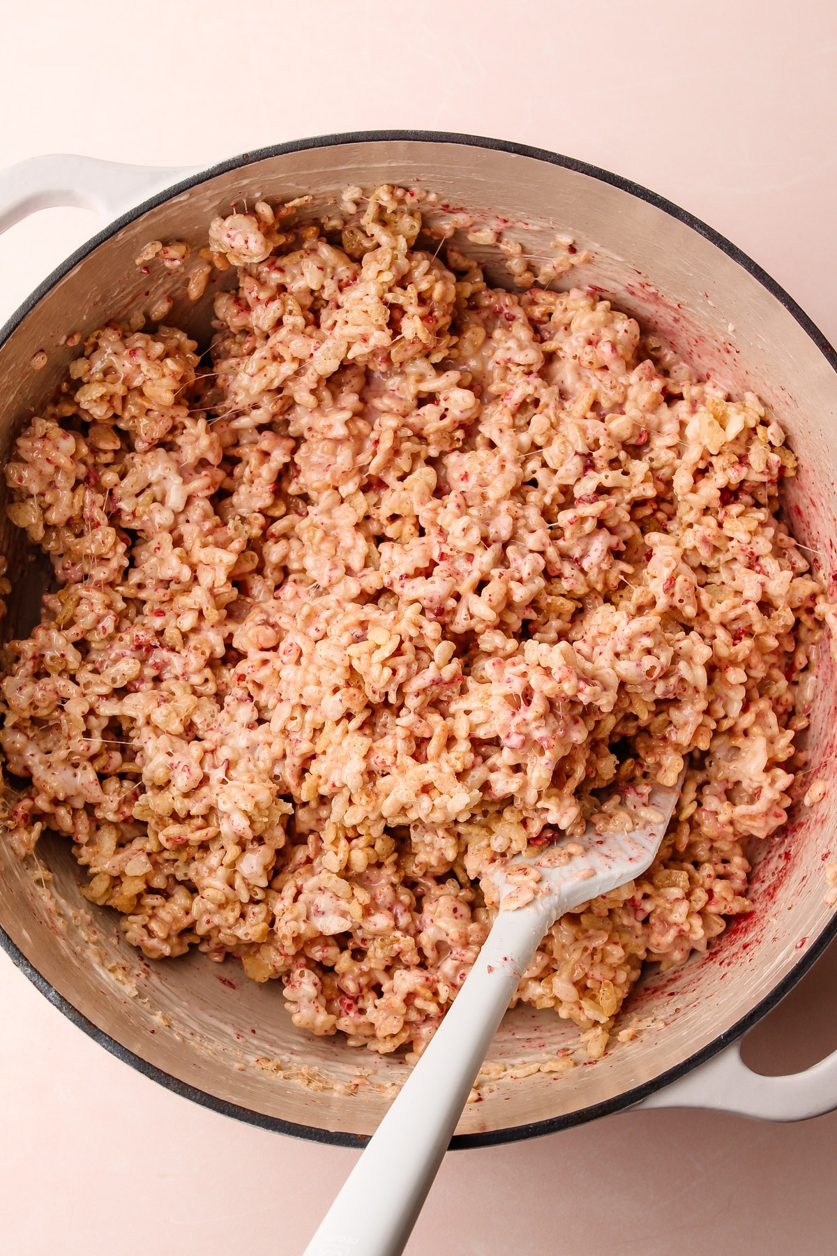 Stirring the strawberry rice crispy treats mixture.