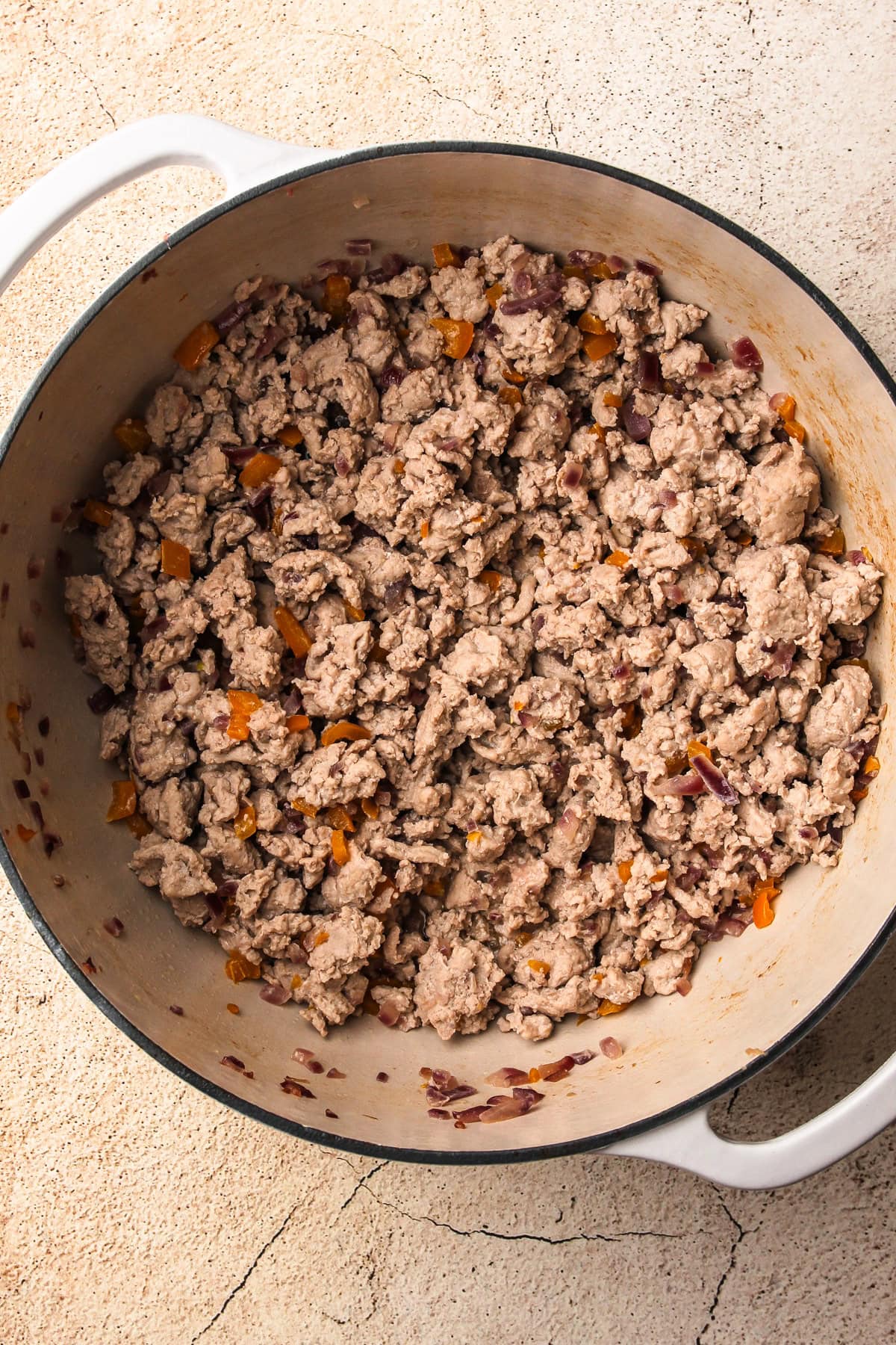 Cooked ground turkey mixed with vegetables, the starting base for a turkey chili recipe.