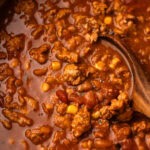 Hearty turkey chili recipe bubbling in a Dutch oven, packed with beans and seasoned meat.