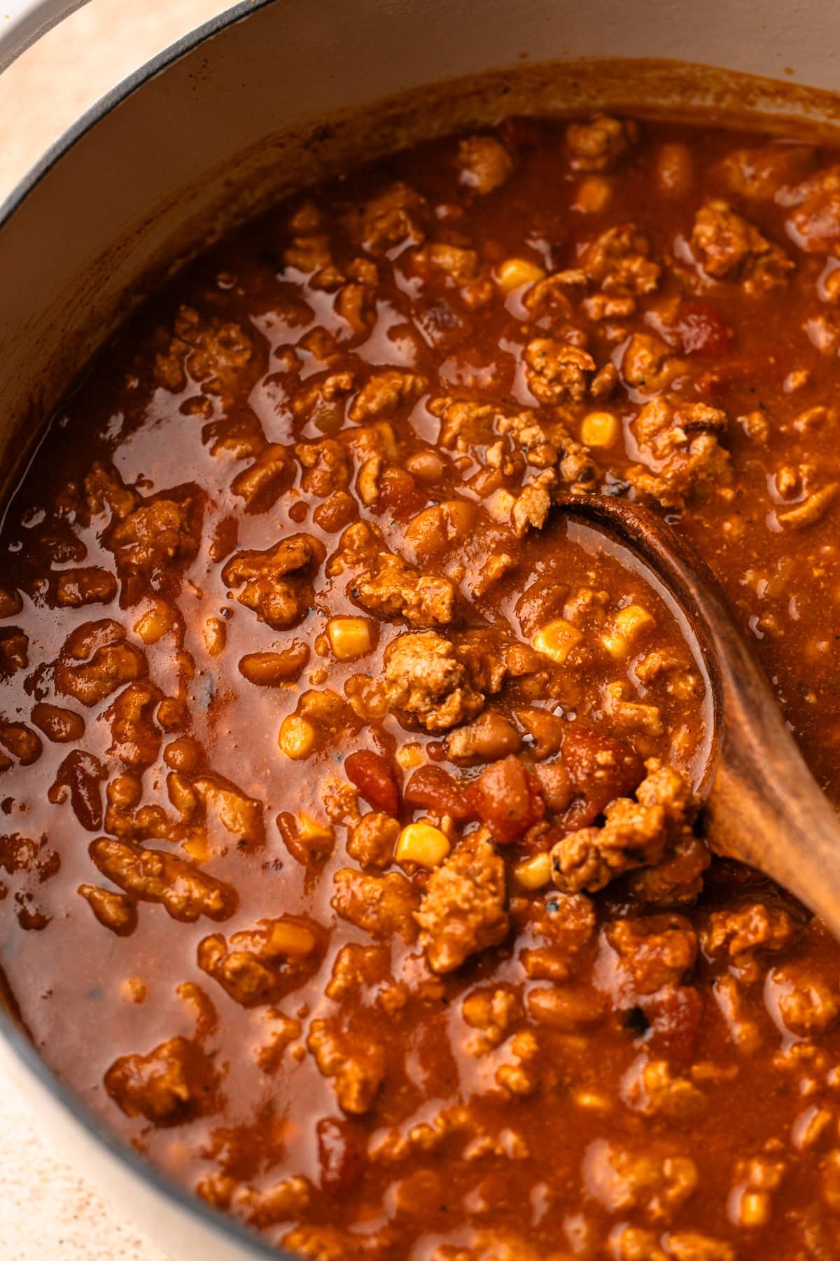 Close-up of simmering turkey chili, showcasing a thick and hearty texture with corn and beans.