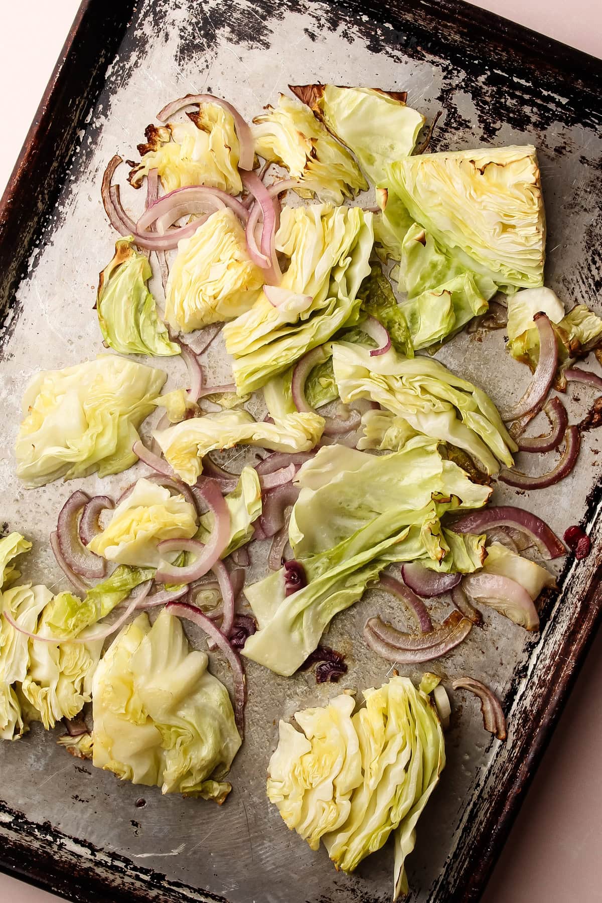 Golden roasted cabbage and onions on a baking sheet, part of an easy pierogi recipe.