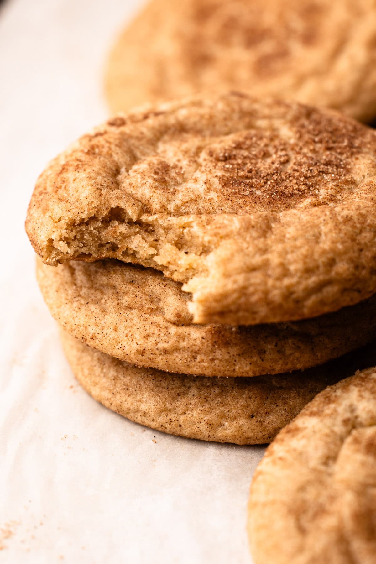 A stack of snickerdoodles with a bite taken out of the top cookie.