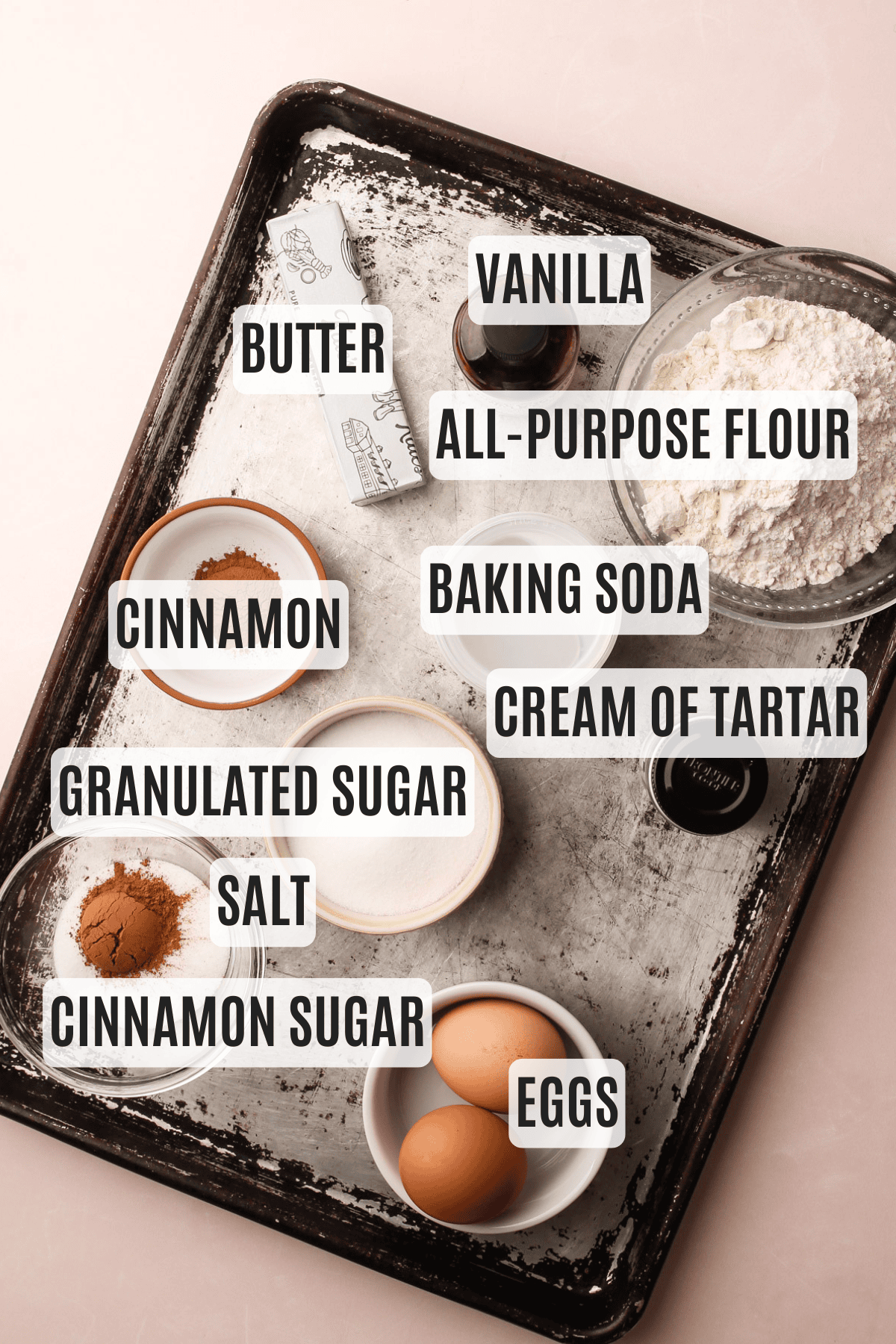 Ingredients for one bowl snickerdoodles labeled on a baking sheet.