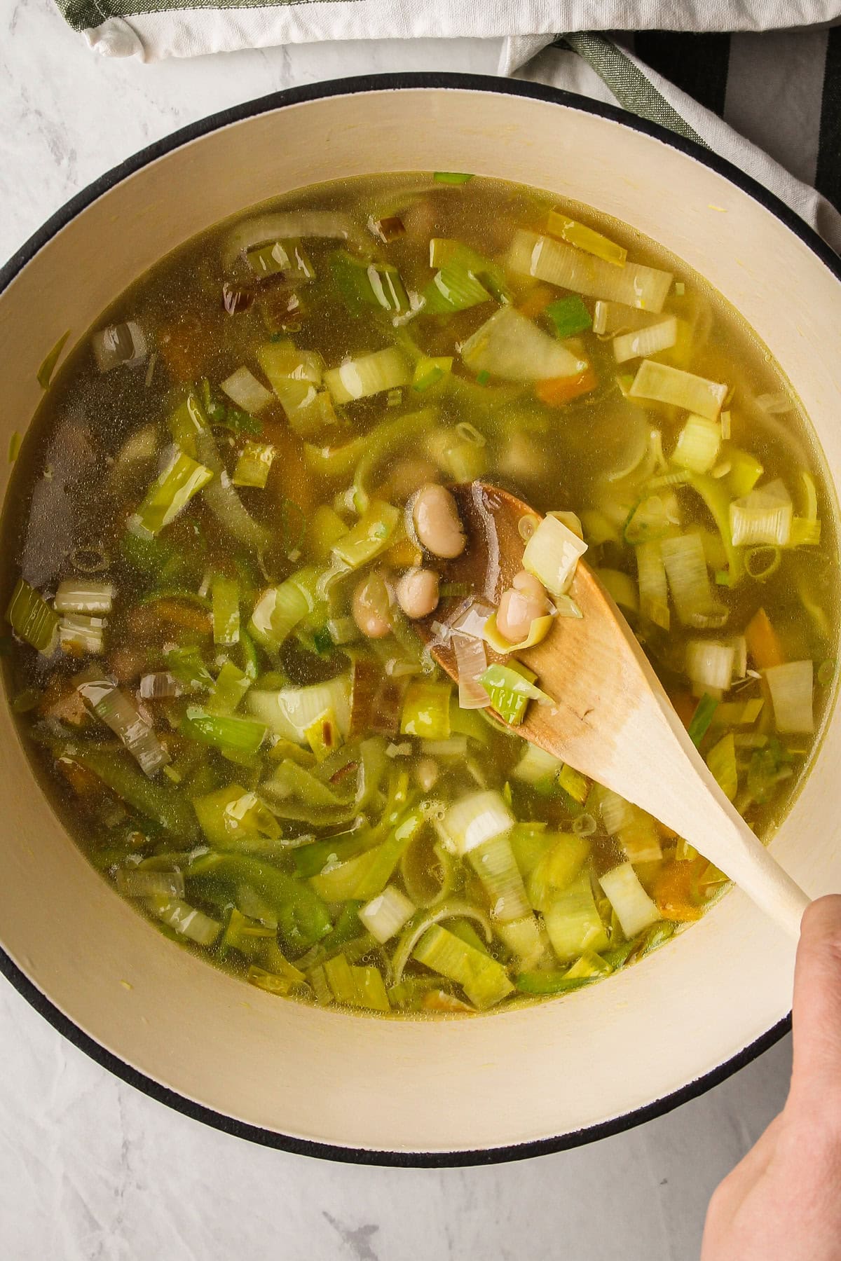 Preparing green goddess soup in a pot.