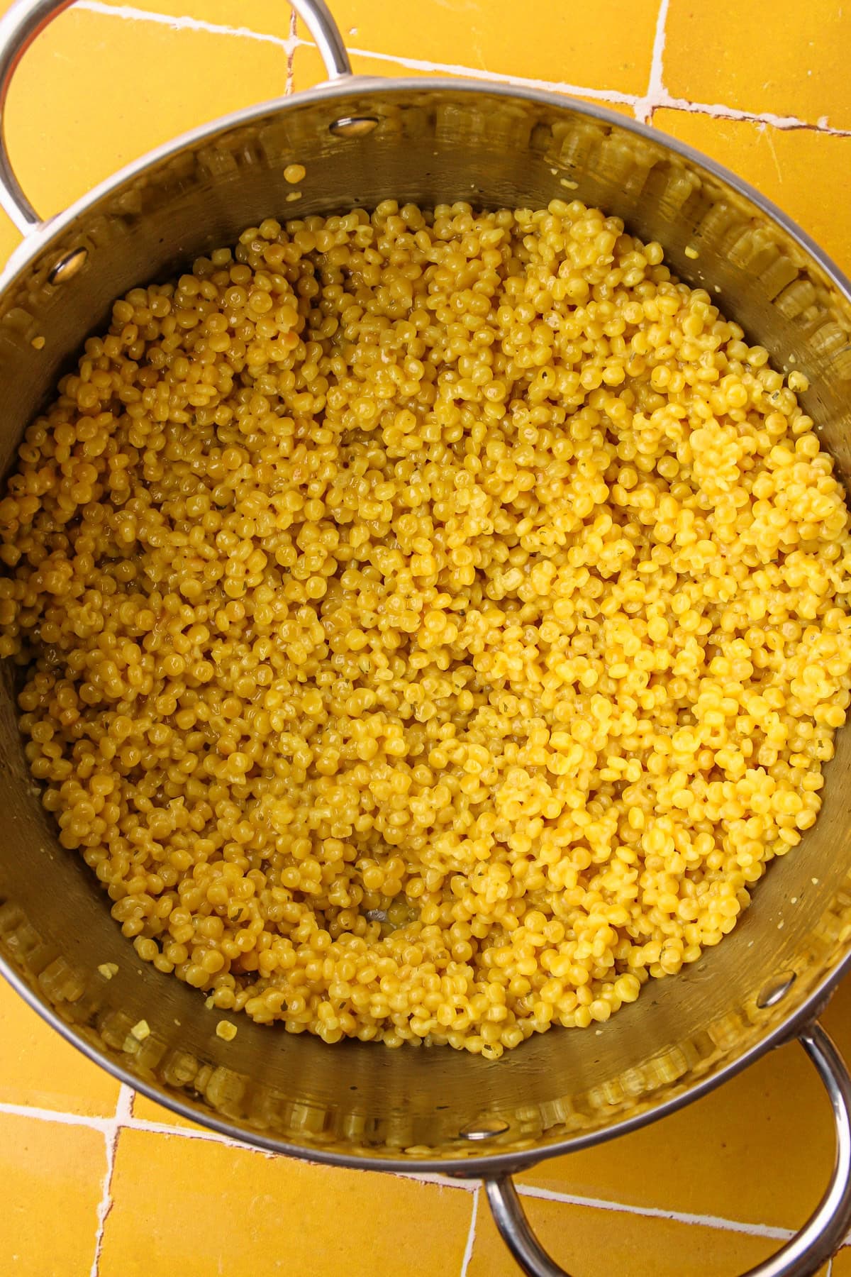 A pot of cooked pearled couscous with garlic before adding in the fresh herbs.