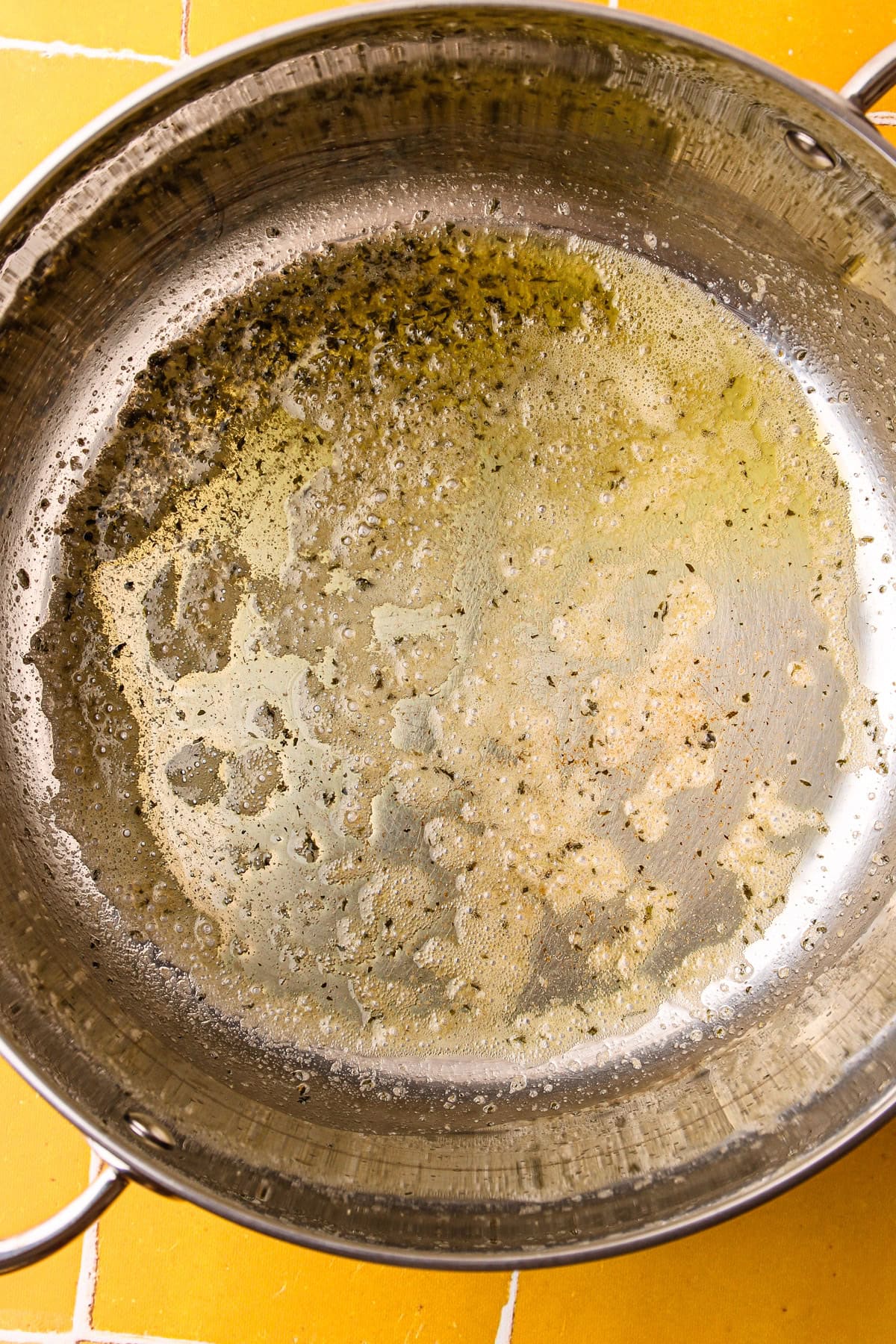 A pot with garlic butter melted in it.