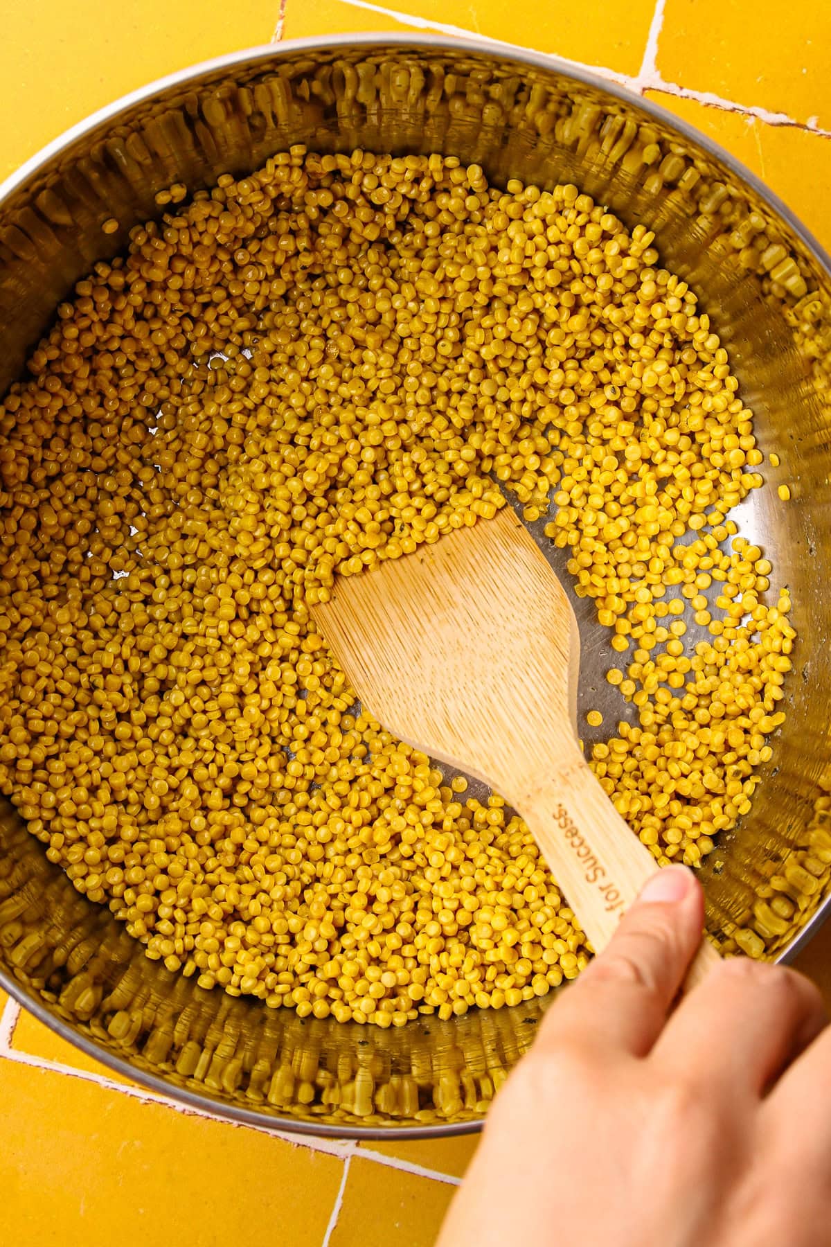 Toasting pearled couscous in garlic butter.