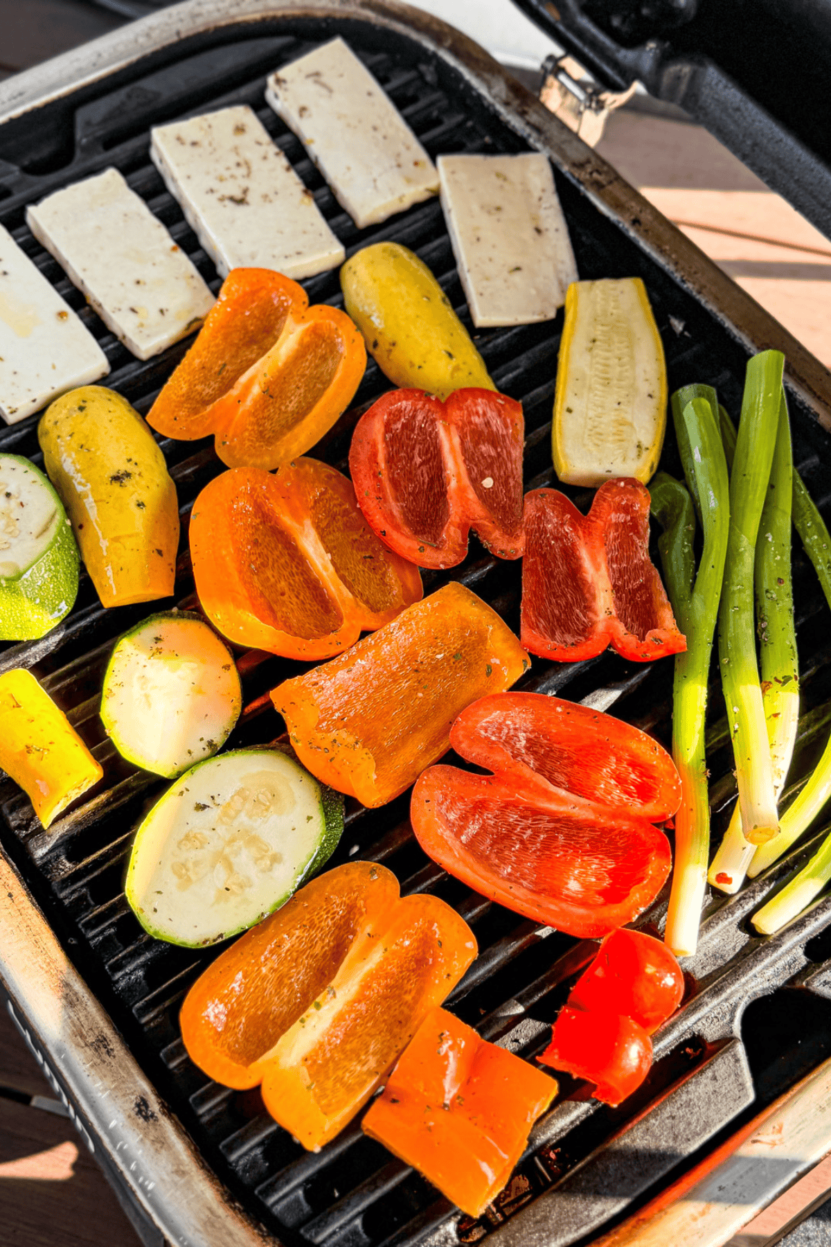 Marinated veggies and halloumi cheese on a grill.