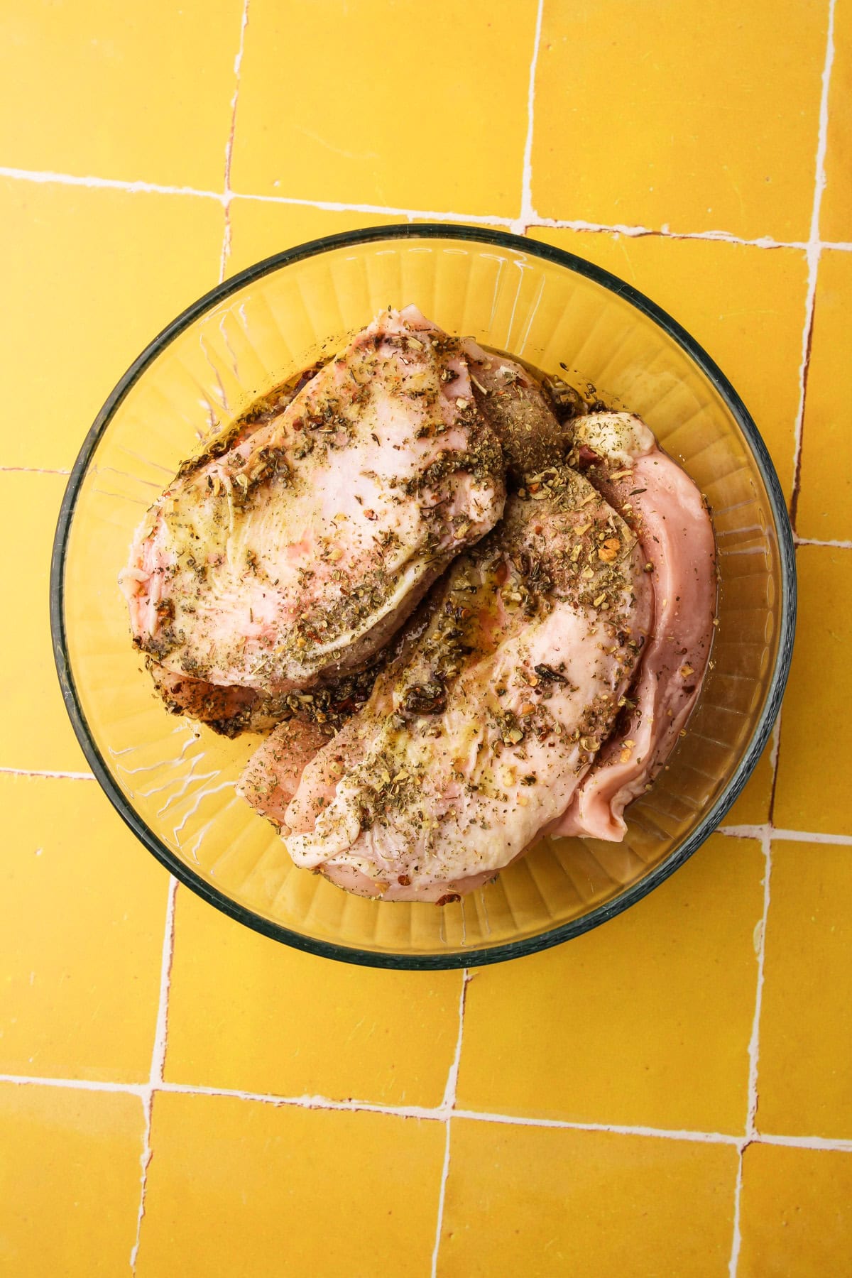 A bowl of marinating chicken breasts that will be cooked on the grill.