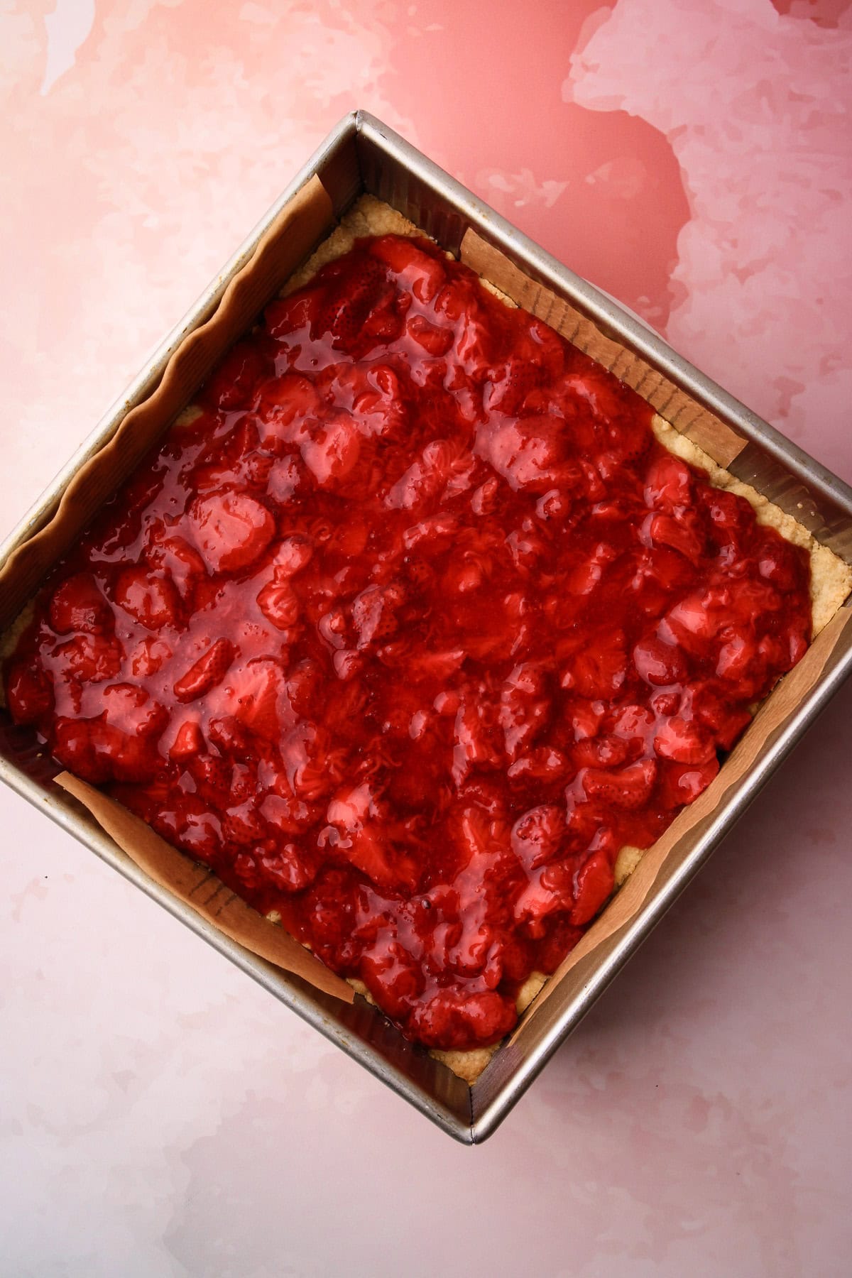 Assembling together strawberry crumble bars.