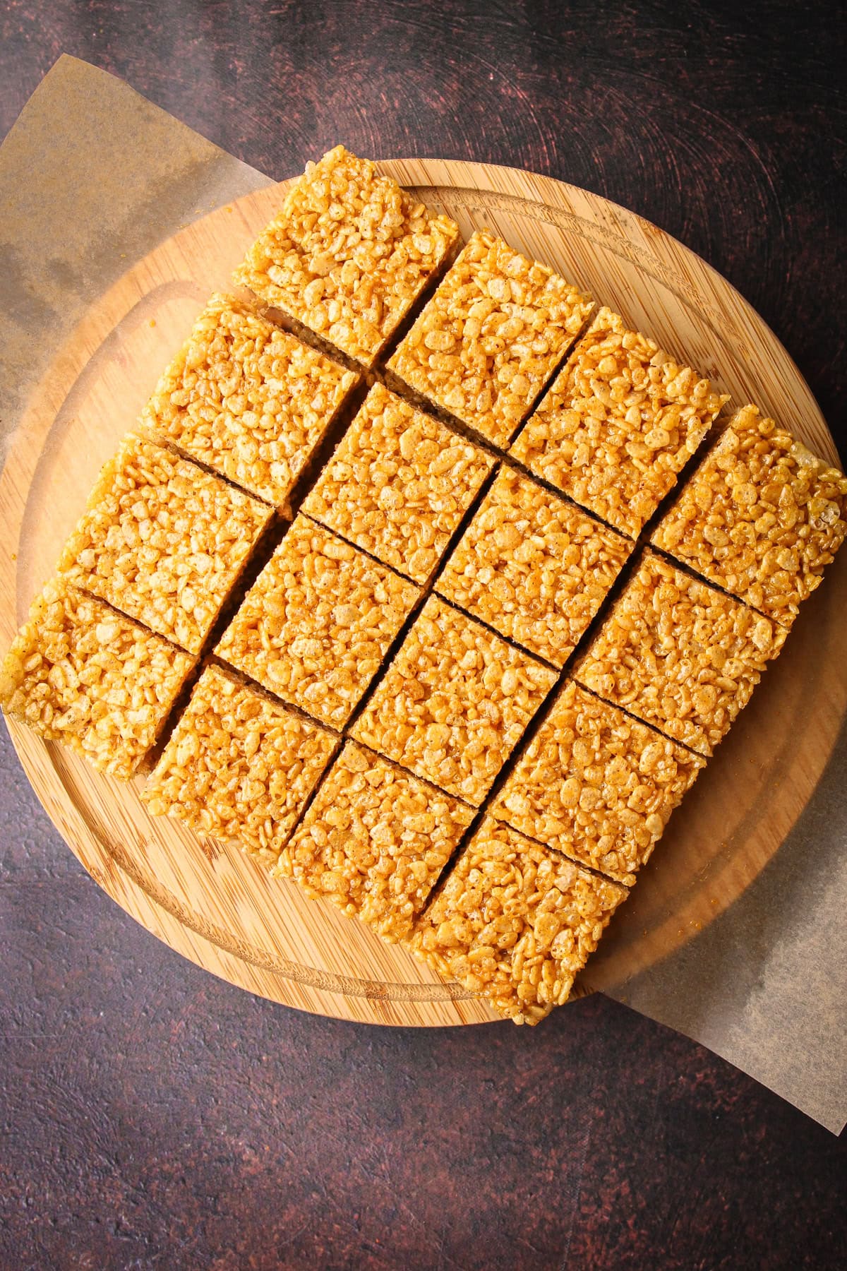 Sliced pumpkin rice crispy treats on a cutting board.