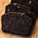 Sliced chocolate zucchini bread on a cutting board.