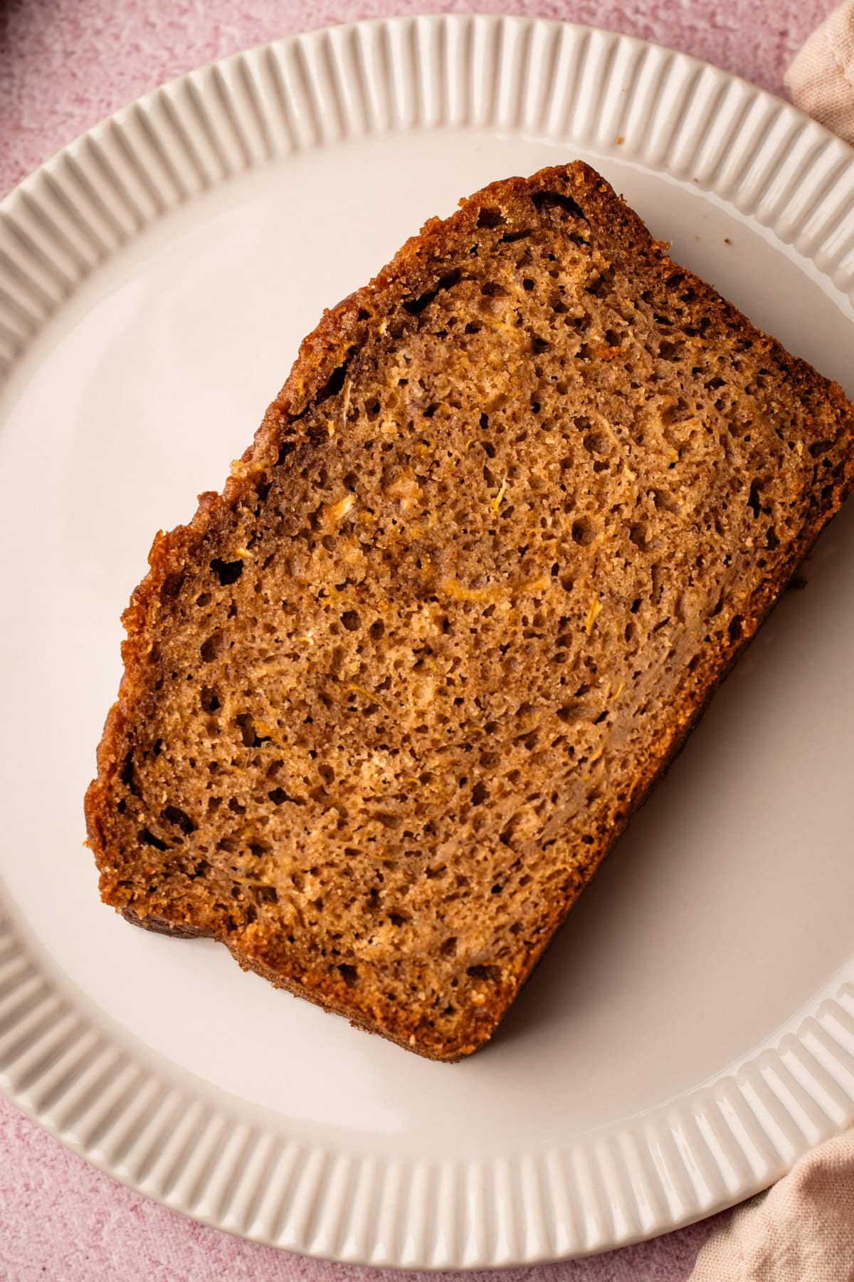 A slice of zucchini bread on a white plate.