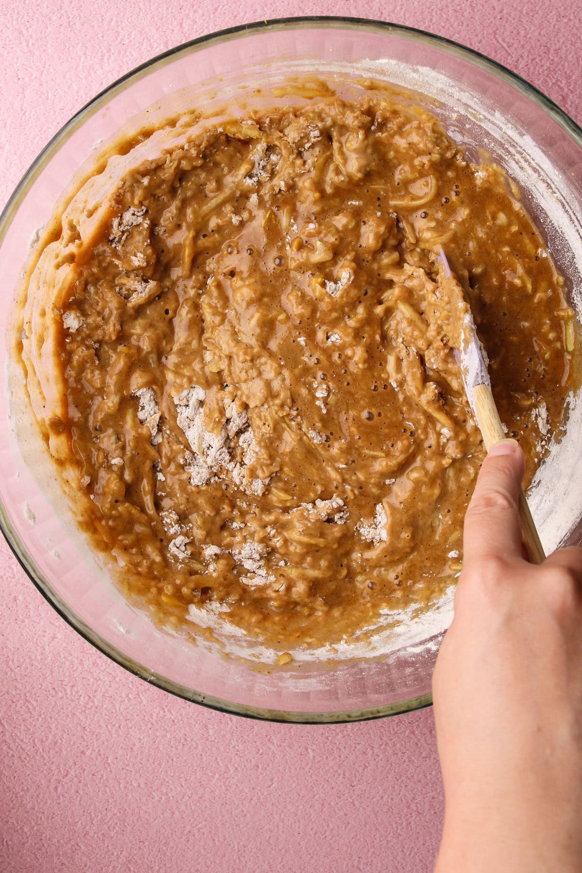 Mixing zucchini bread batter together in a bowl.