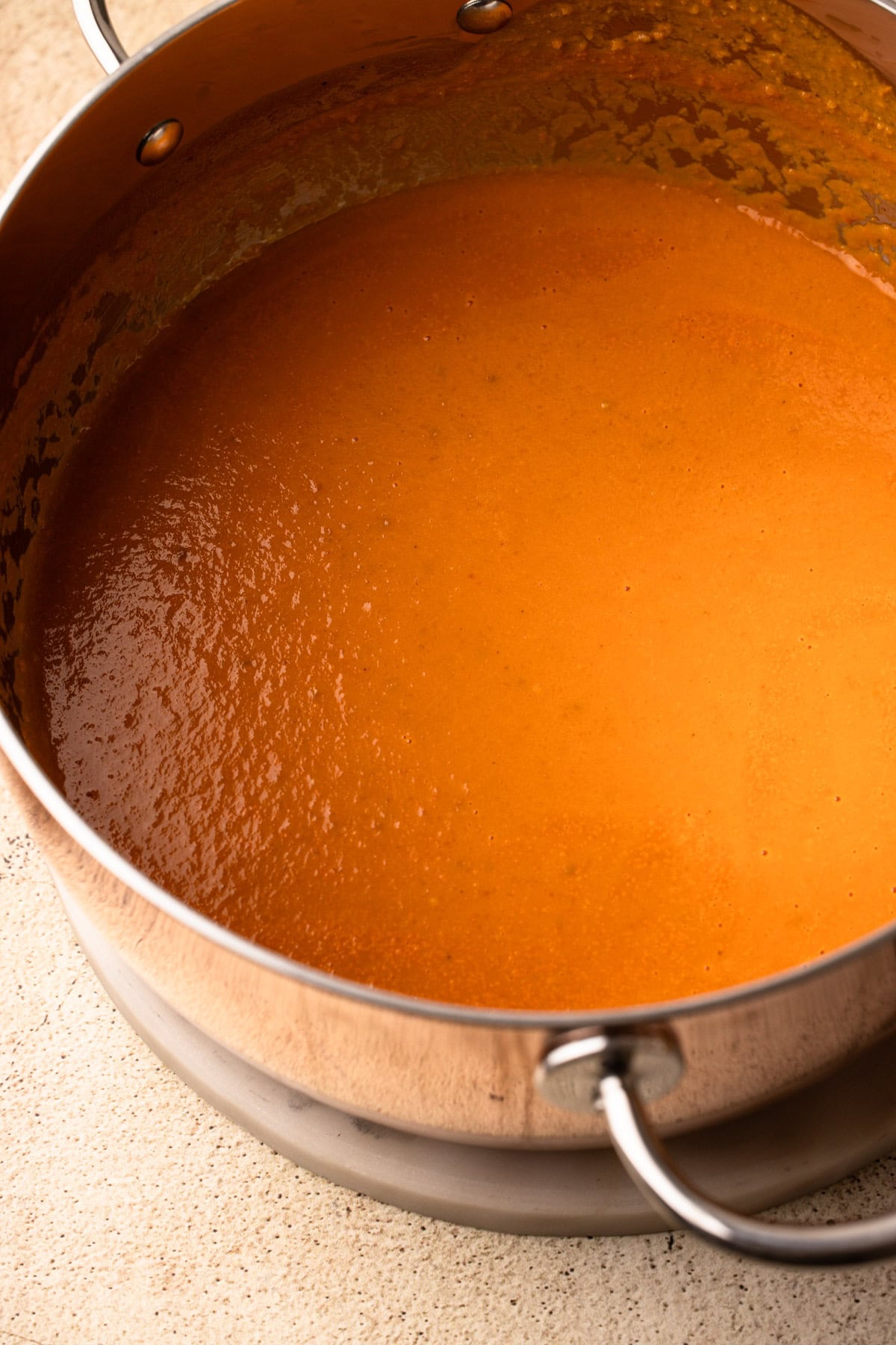 A close view of creamy roasted tomato soup in the pot.