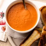 Homemade tomato soup served with grilled cheese.
